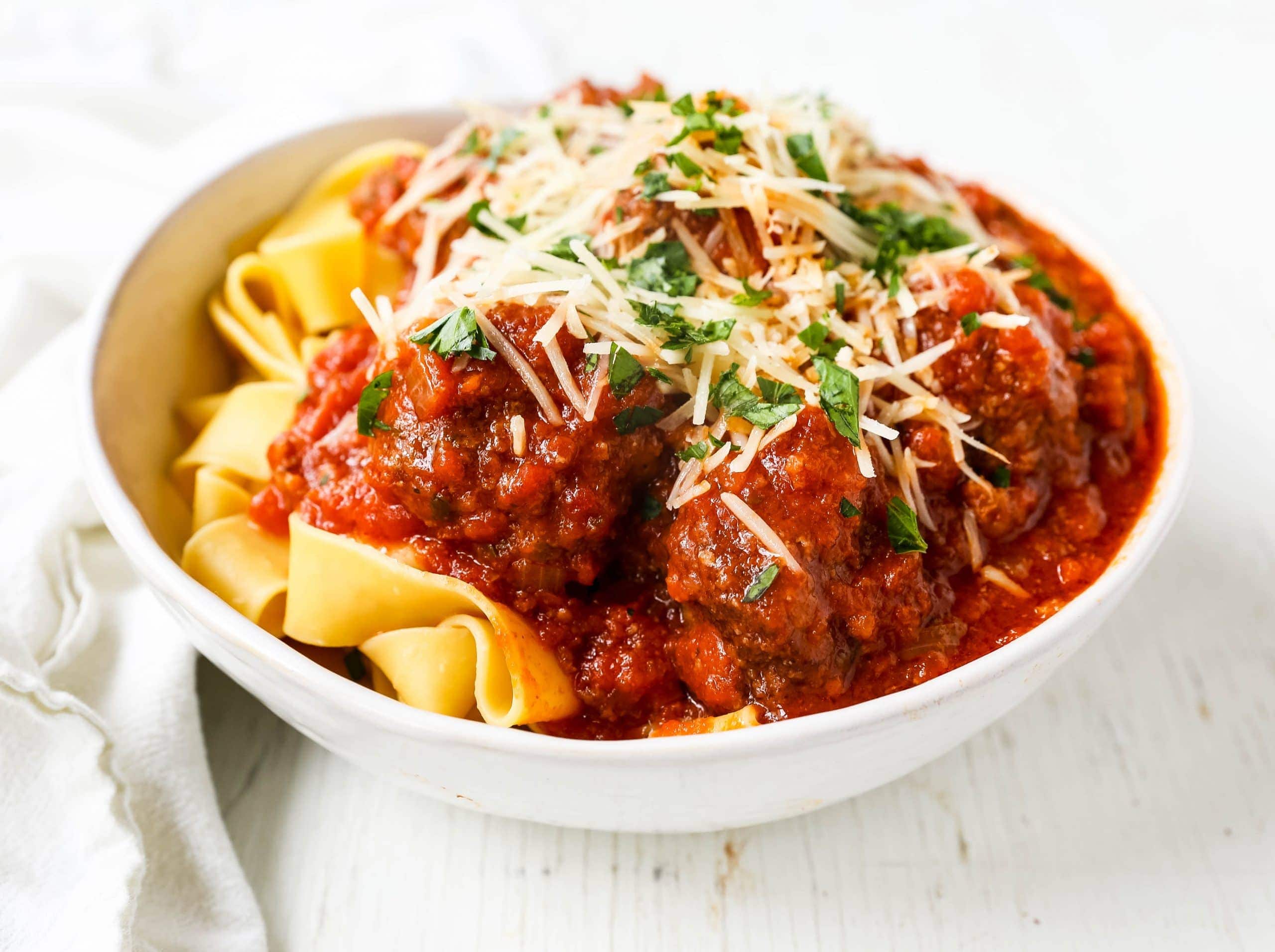 Slow Cooker Meatballs. Tender, moist homemade meatballs made with ground beef, sausage, parmesan cheese, bread crumbs, and spices. Slow cooking the meatballs make the most melt-in-your-mouth meatball! www.modernhoney.com #meatball #meatballs #italian #italianfood #pasta 