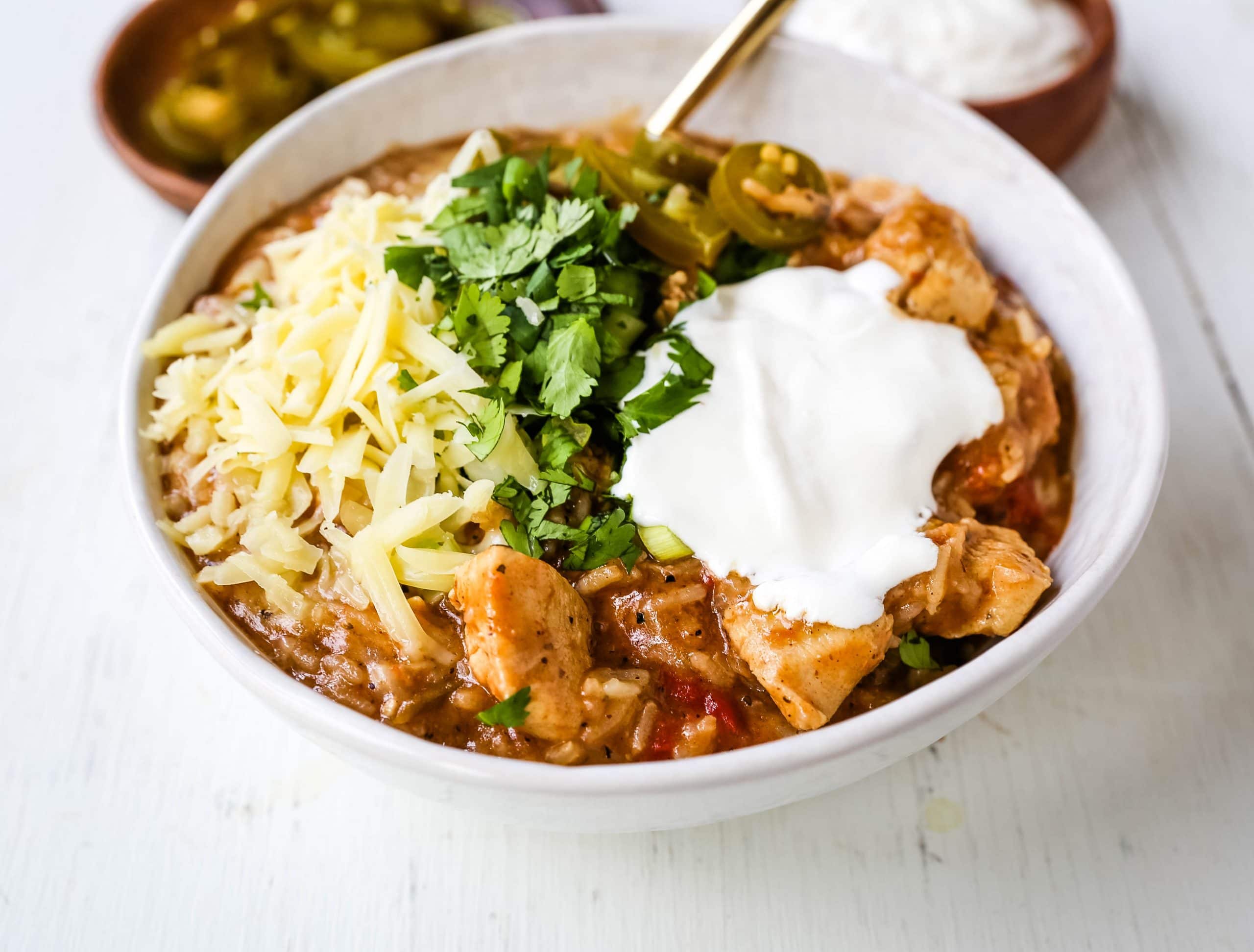 Cheesy Mexican Chicken and Rice Skillet Mexican chicken with green chilies, tomatoes, Mexican spices, rice, and cheese. An easy 30-minute dinner recipe! www.modernhoney.com #skilletdinner #30minutemeal #30minutedinner #mexicanfood #mexican