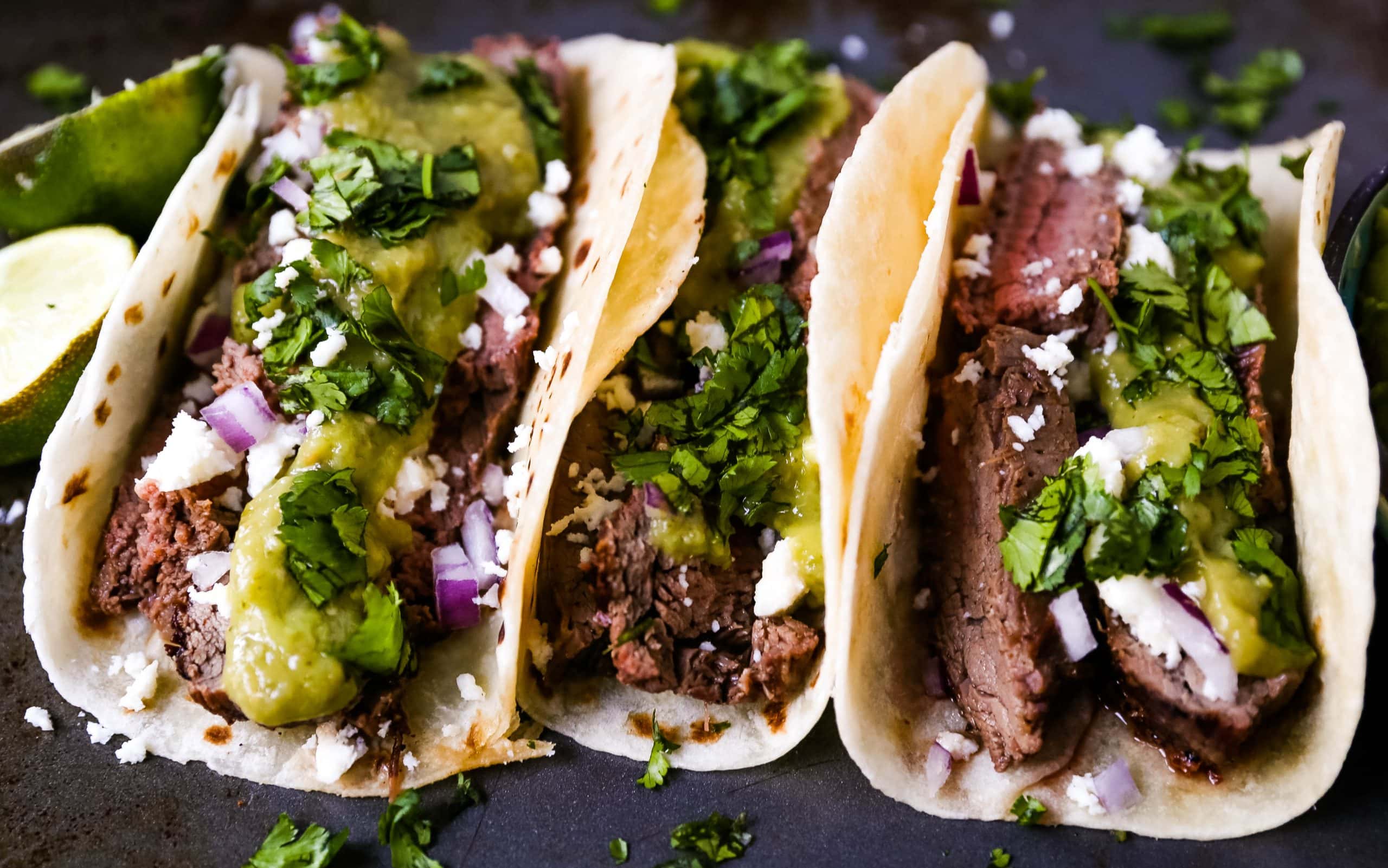 Grilled Steak Tacos. Juicy marinated grilled steak tacos with fresh cilantro, avocado, and salsa. The most flavorful and tender steak tacos recipe! www.modernhoney.com #tacos #steaktacos #steak #beeftacos