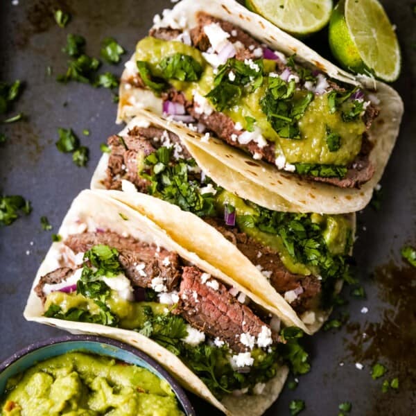 Grilled Steak Tacos. Juicy marinated grilled steak tacos with fresh cilantro, avocado, and salsa. The most flavorful and tender steak tacos recipe! www.modernhoney.com #tacos #steaktacos #steak #beeftacos