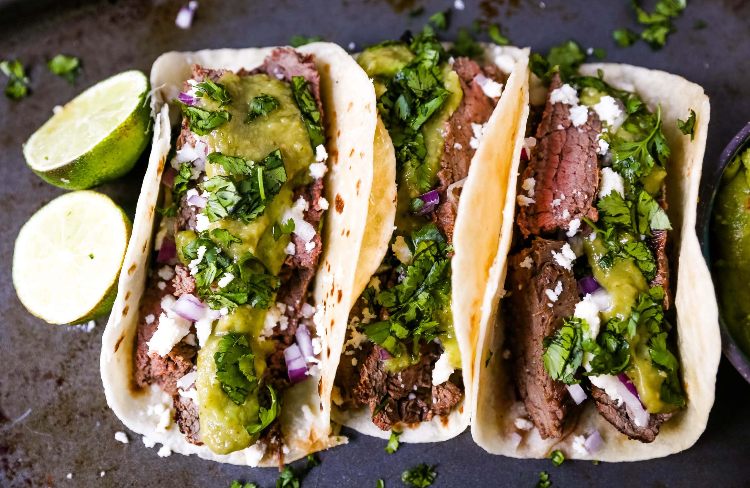 Grilled Steak Tacos. Juicy marinated grilled steak tacos with fresh cilantro, avocado, and salsa. The most flavorful and tender steak tacos recipe! www.modernhoney.com #tacos #steaktacos #steak #beeftacos