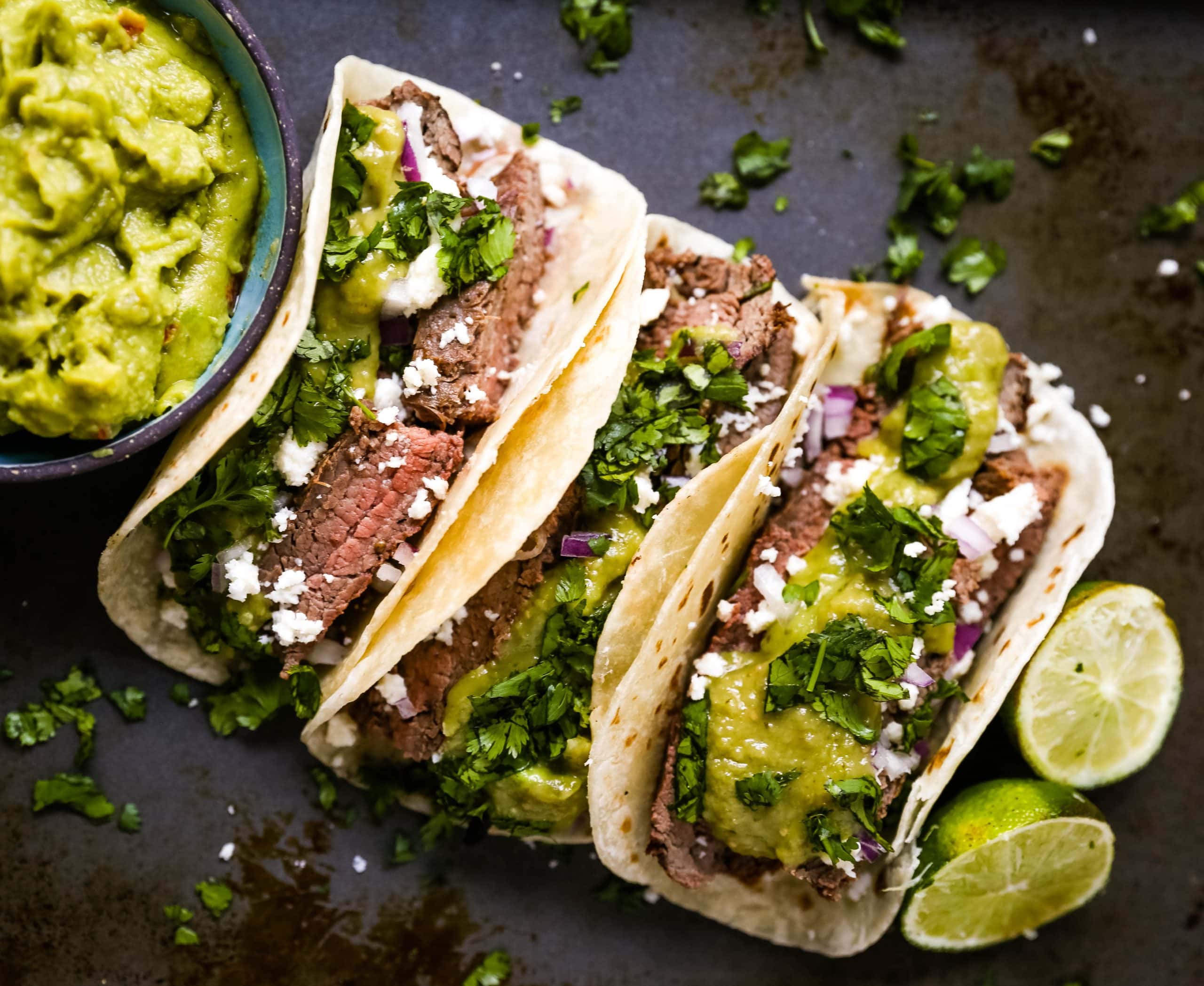 Grilled Steak Tacos. Juicy marinated grilled steak tacos with fresh cilantro, avocado, and salsa. The most flavorful and tender steak tacos recipe! www.modernhoney.com #tacos #steaktacos #steak #beeftacos