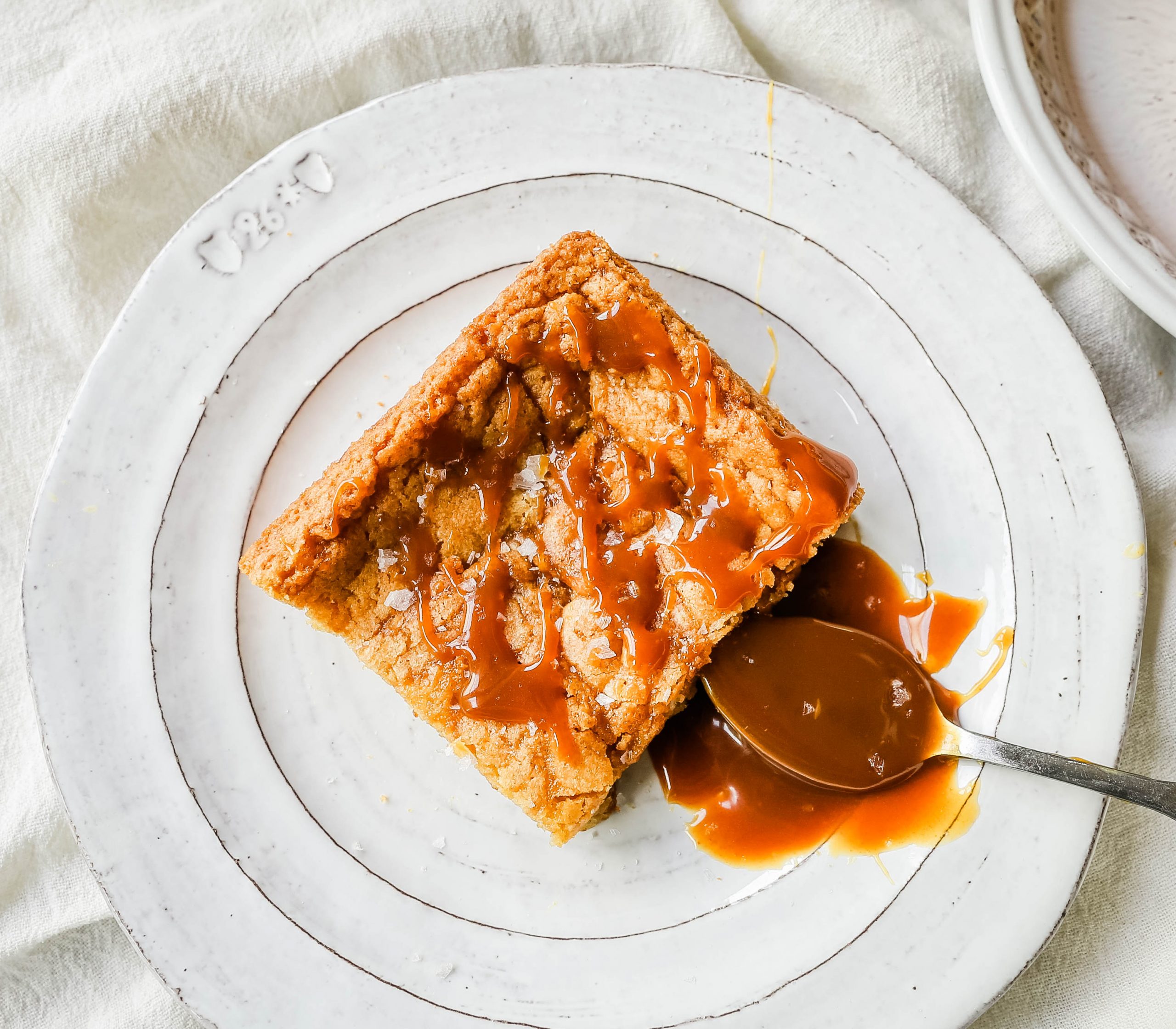 Salted Caramel Blondies. Soft chewy vanilla blondies swirled with salted caramel and baked until golden. The Best Sea Salt Caramel Blondies! www.modernhoney.com #blondies #caramel #caramelblondies #dessertbars