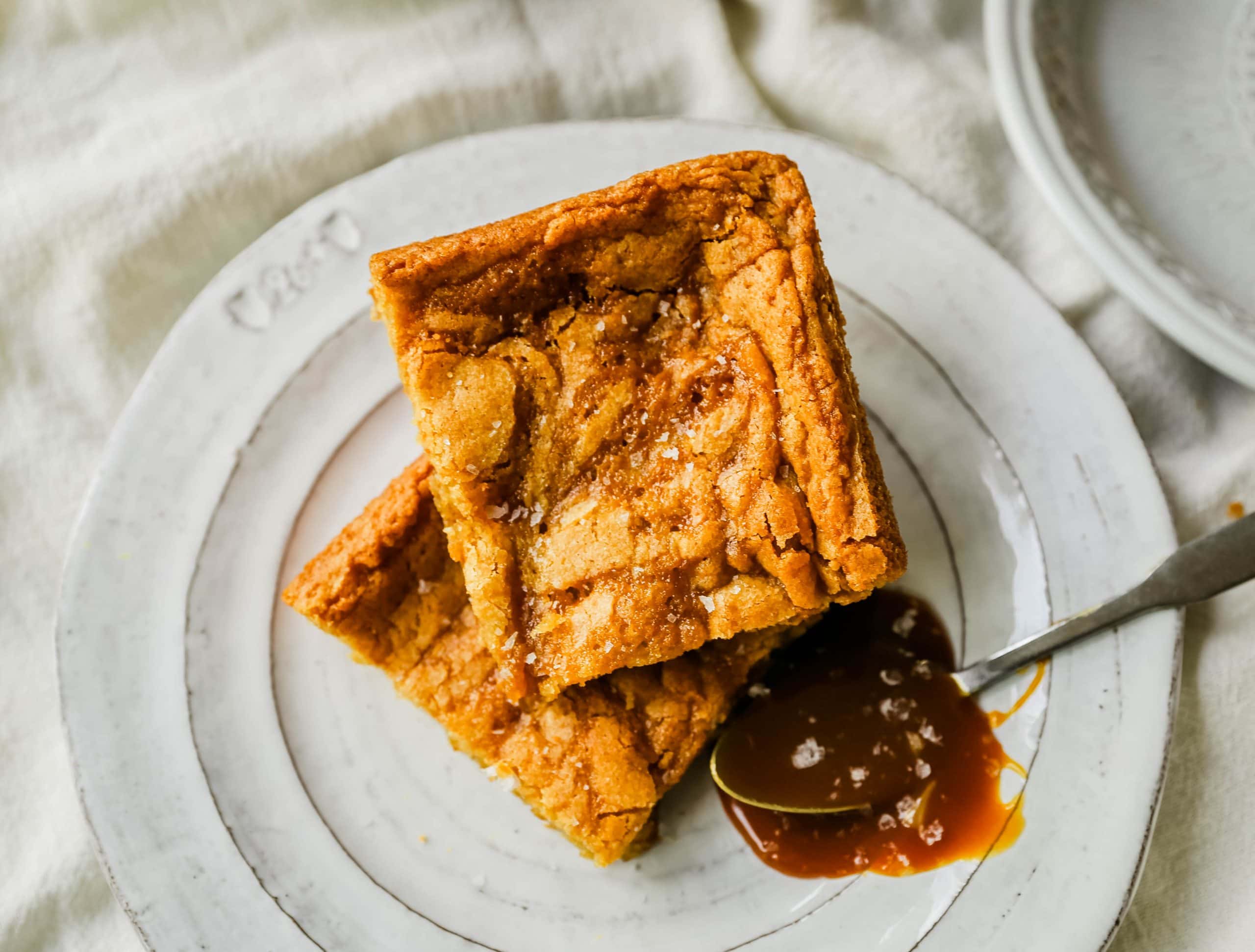 Salted Caramel Blondies. Soft chewy vanilla blondies swirled with salted caramel and baked until golden. The Best Sea Salt Caramel Blondies! www.modernhoney.com #blondies #caramel #caramelblondies #dessertbars