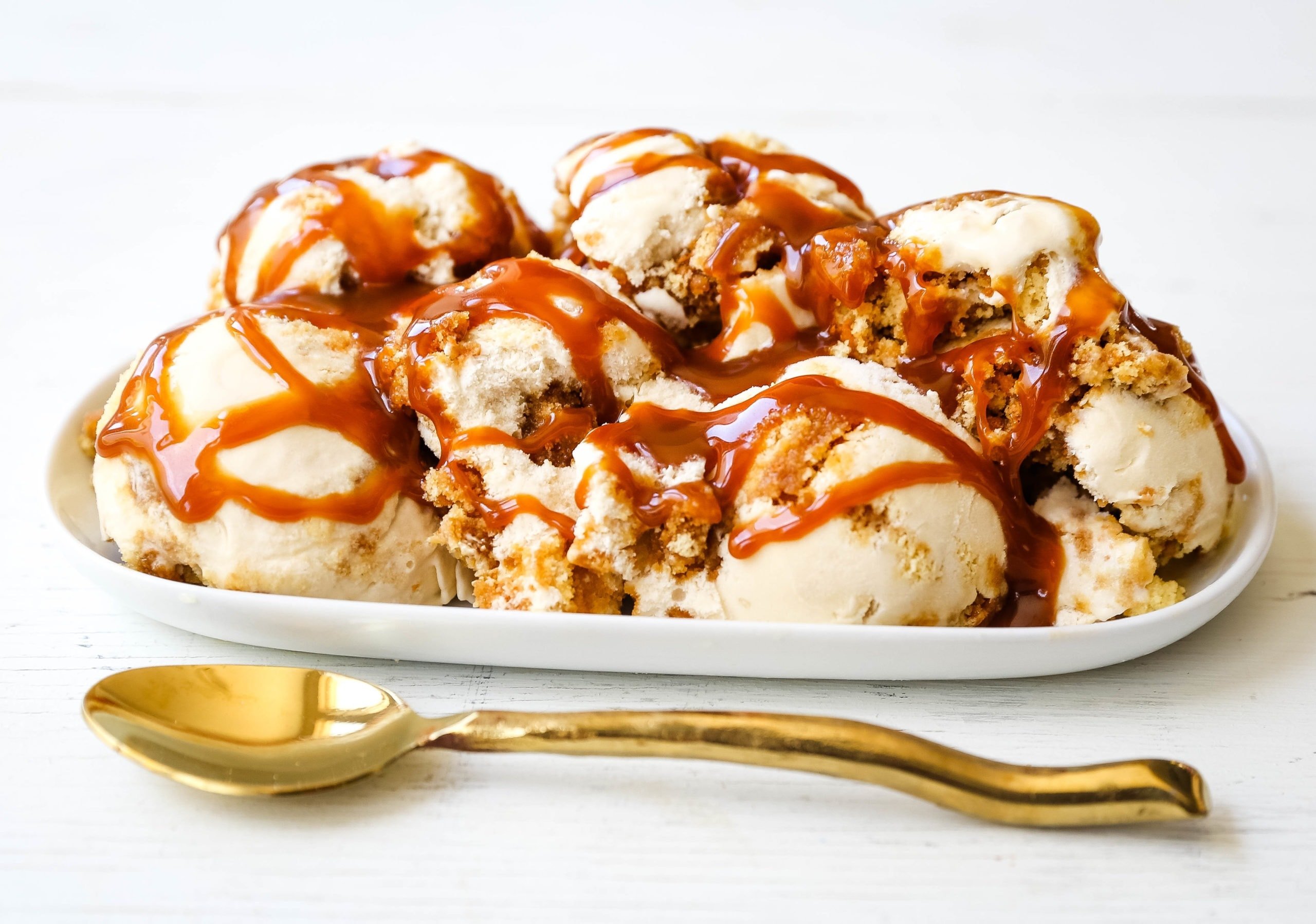 Caramel Gooey Butter Cake Ice Cream. Creamy homemade vanilla ice cream with chunks of homemade butter cake and swirls of decadent sweet caramel. www.modernhoney.com #icecream #homemadeicecream #caramel