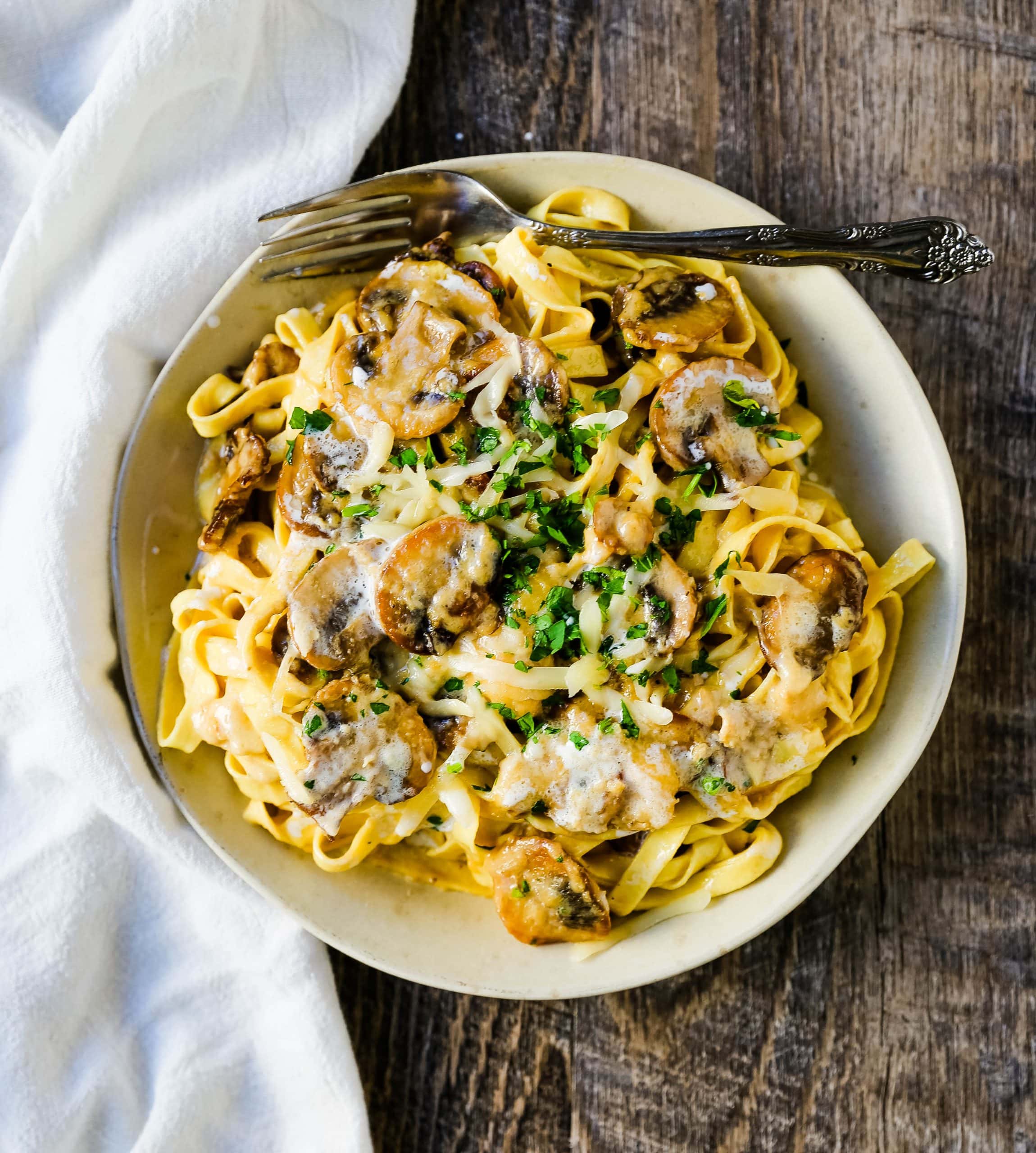 Creamy Mushroom Fettuccine. Sauteed mushrooms in a creamy parmesan cheese alfredo sauce tossed with fettuccine noodles. #mushrooms #fettuccine #mushroomfettuccinealfredo #mushroompasta