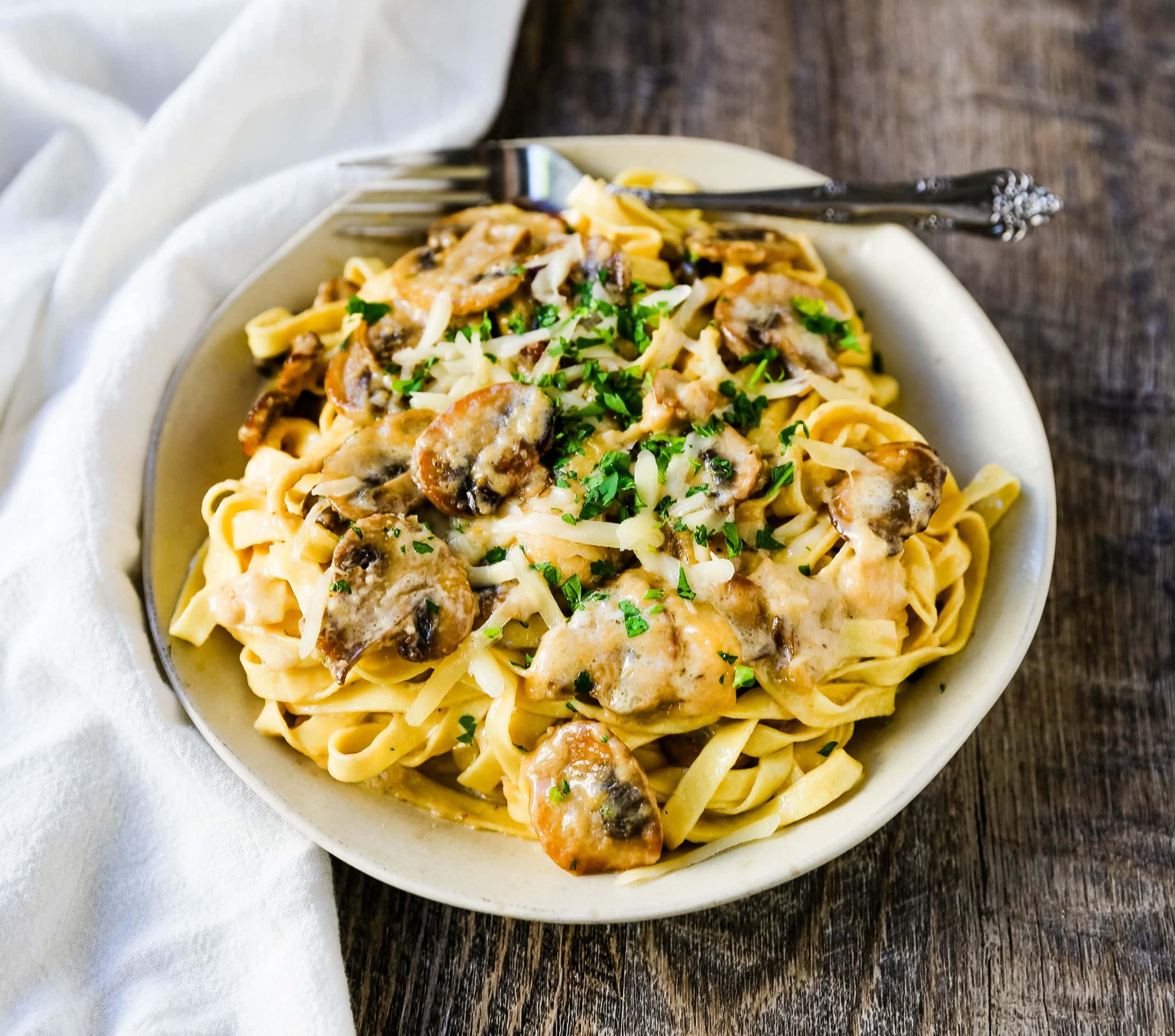 Creamy Mushroom Fettuccine. Sauteed mushrooms in a creamy parmesan cheese alfredo sauce tossed with fettuccine noodles. #mushrooms #fettuccine #mushroomfettuccinealfredo #mushroompasta