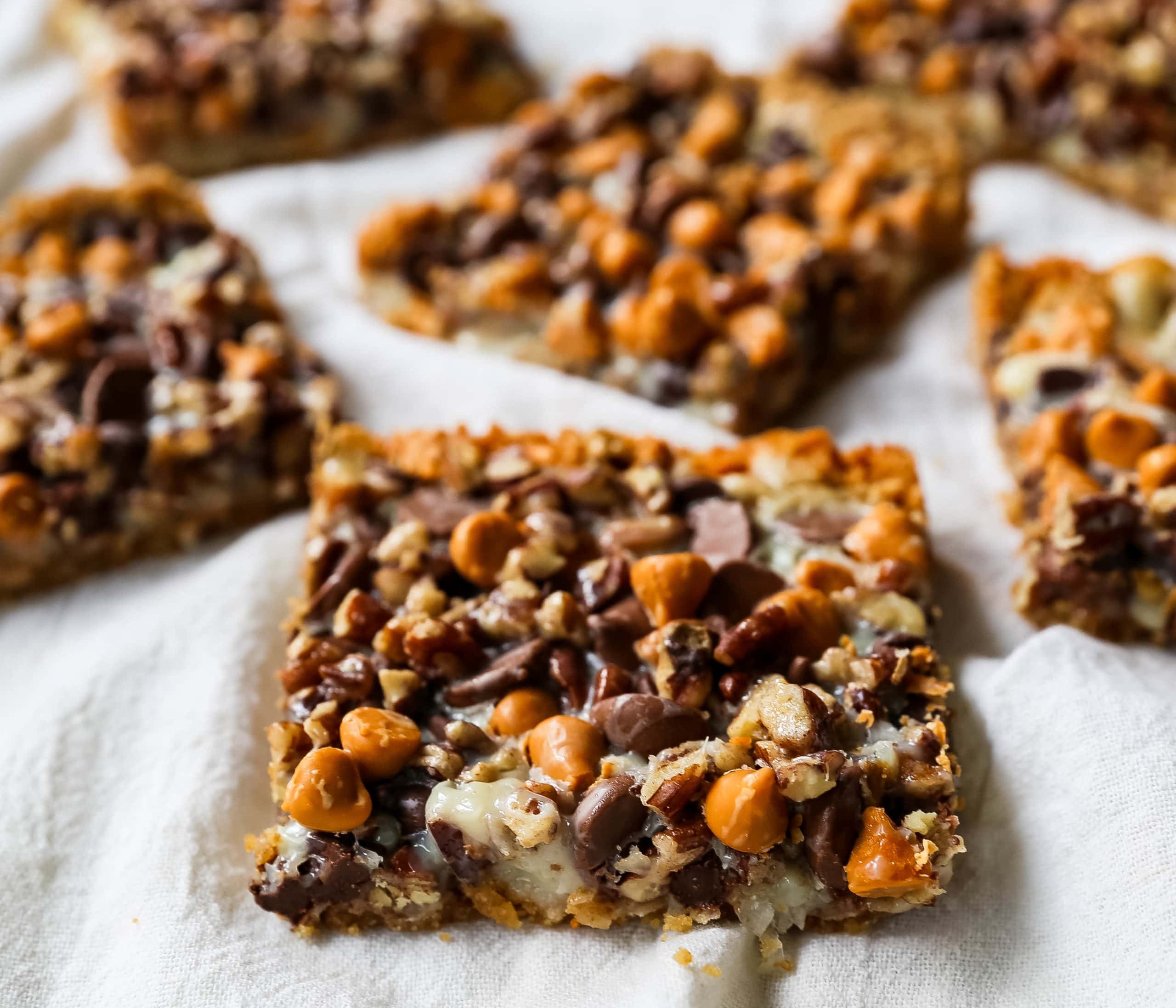 7-Layer Magic Bars. The famous dessert bars made with a graham cracker crust, sweetened flaked coconut, chocolate chips, butterscotch chips, nuts, all drizzled with sweetened condensed milk. The perfect dessert bar recipe! www.modernhoney.com #7layerbars #magicbars #magiccookiebars #sevenlayerbars 