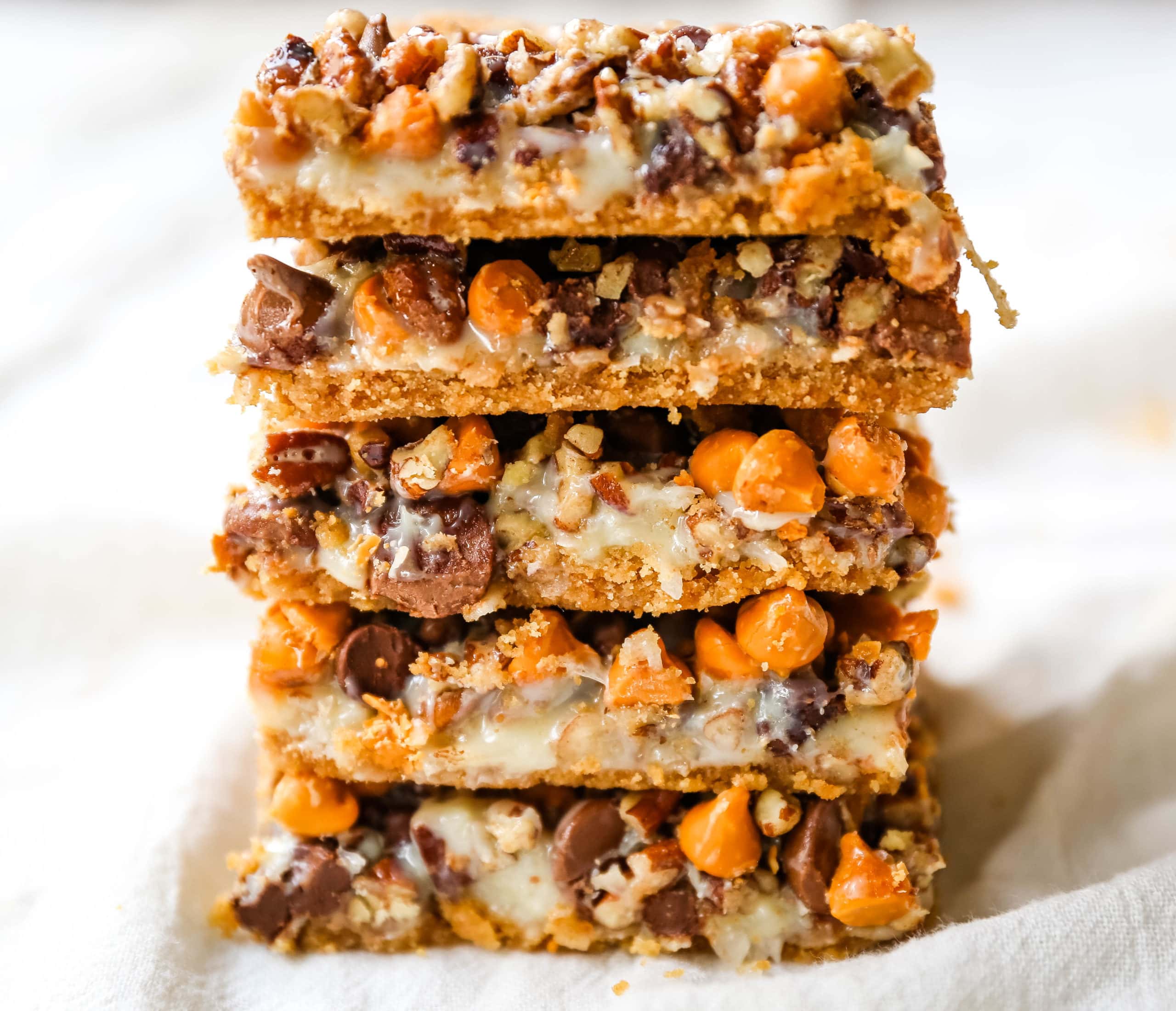 7-Layer Magic Bars. The famous dessert bars made with a graham cracker crust, sweetened flaked coconut, chocolate chips, butterscotch chips, nuts, all drizzled with sweetened condensed milk. The perfect dessert bar recipe! www.modernhoney.com #7layerbars #magicbars #magiccookiebars #sevenlayerbars 