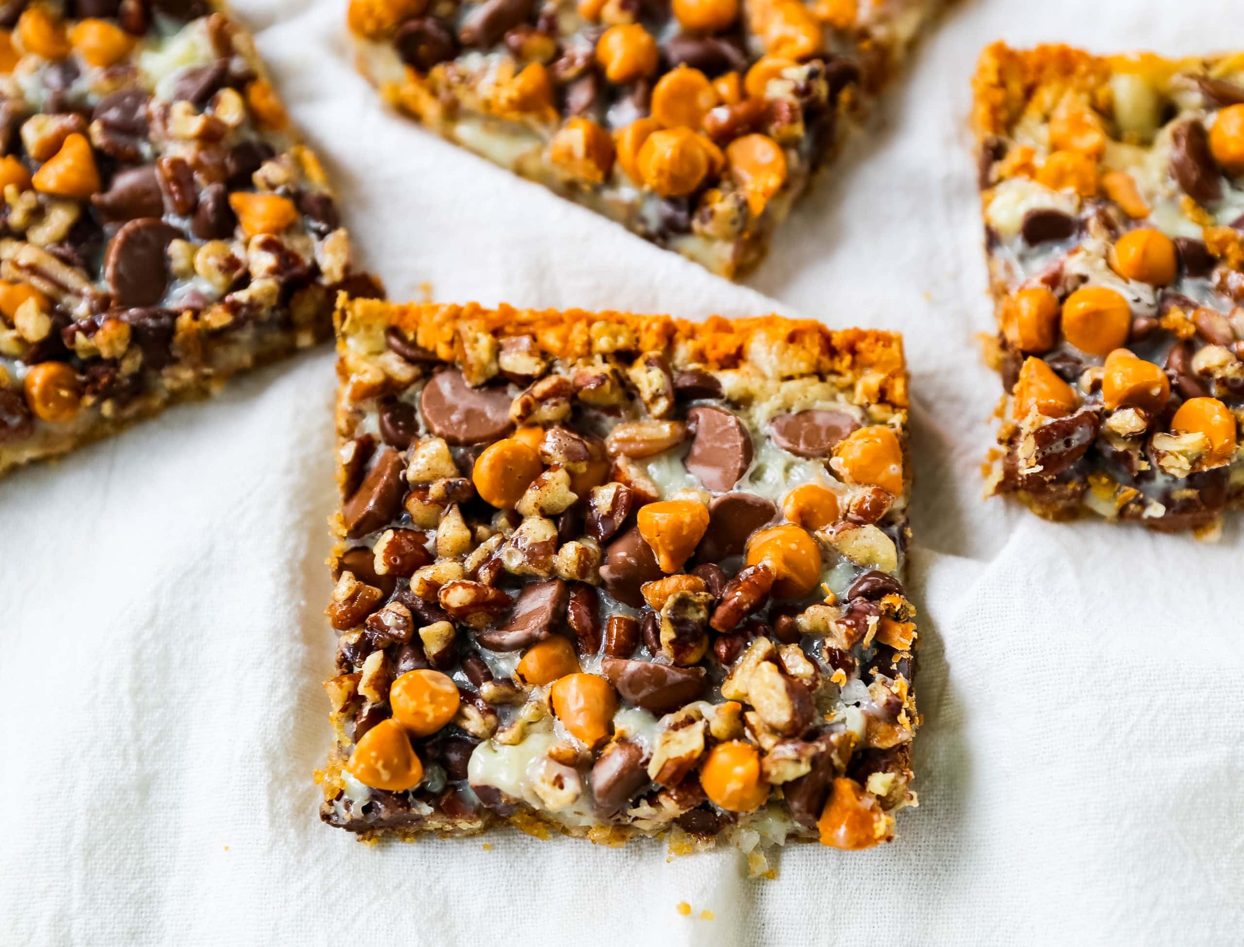 7-Layer Magic Bars. The famous dessert bars made with a graham cracker crust, sweetened flaked coconut, chocolate chips, butterscotch chips, nuts, all drizzled with sweetened condensed milk. The perfect dessert bar recipe! www.modernhoney.com #7layerbars #magicbars #magiccookiebars #sevenlayerbars 