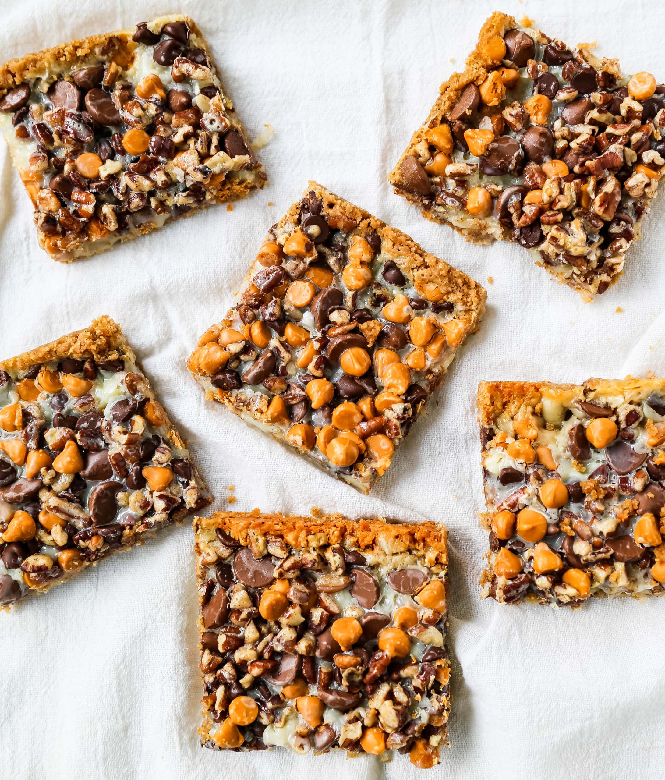 7-Layer Magic Bars. The famous dessert bars made with a graham cracker crust, sweetened flaked coconut, chocolate chips, butterscotch chips, nuts, all drizzled with sweetened condensed milk. The perfect dessert bar recipe! www.modernhoney.com #7layerbars #magicbars #magiccookiebars #sevenlayerbars 