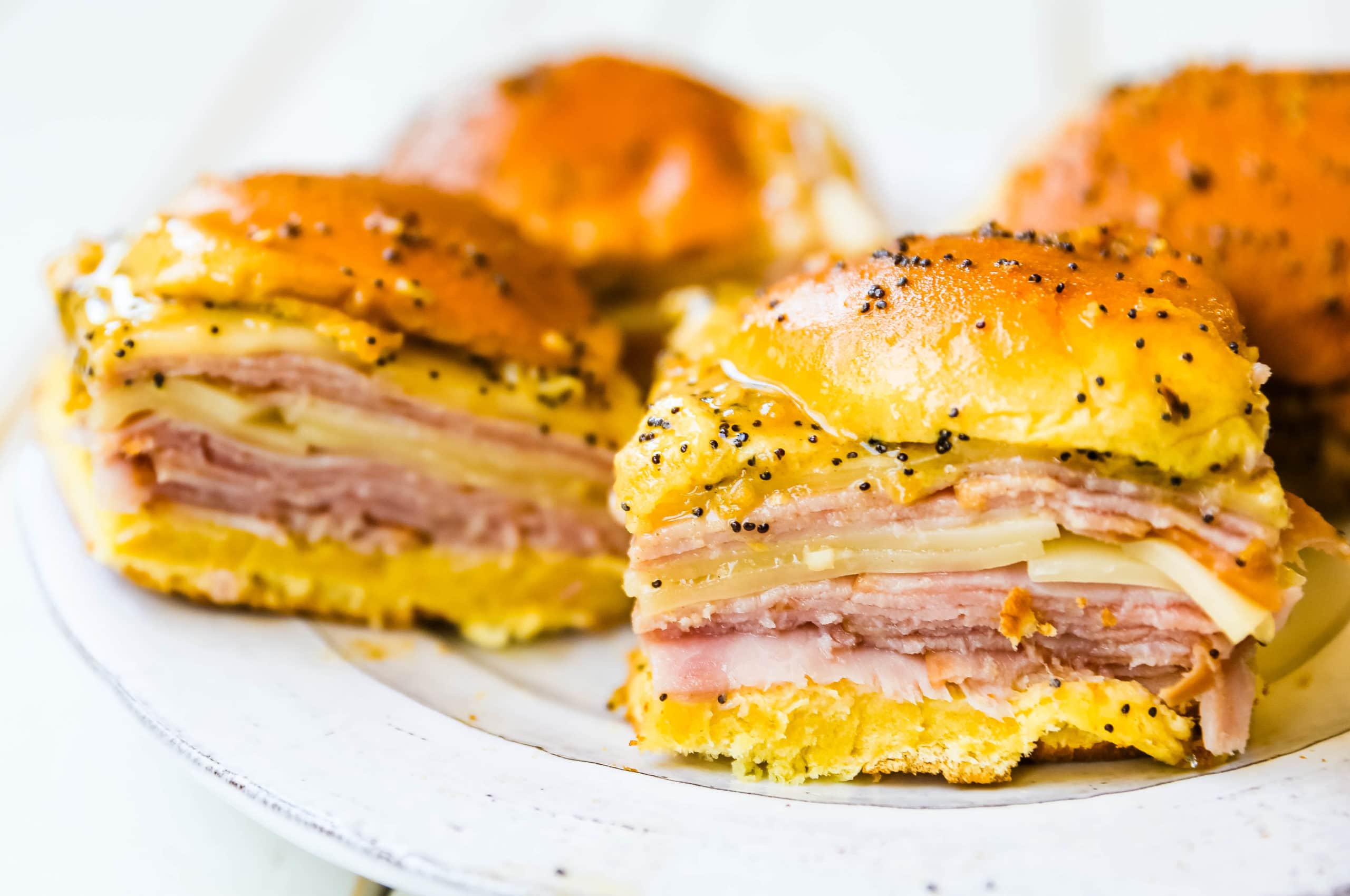 Ham and Cheese Sliders  These baked ham and cheese sliders and layered with ham, melted cheese, on a Hawaiian sweet roll, and basted with a flavorful, buttery sauce. www.modernhoney.com #sandwiches #sliders #hamandcheesesliders