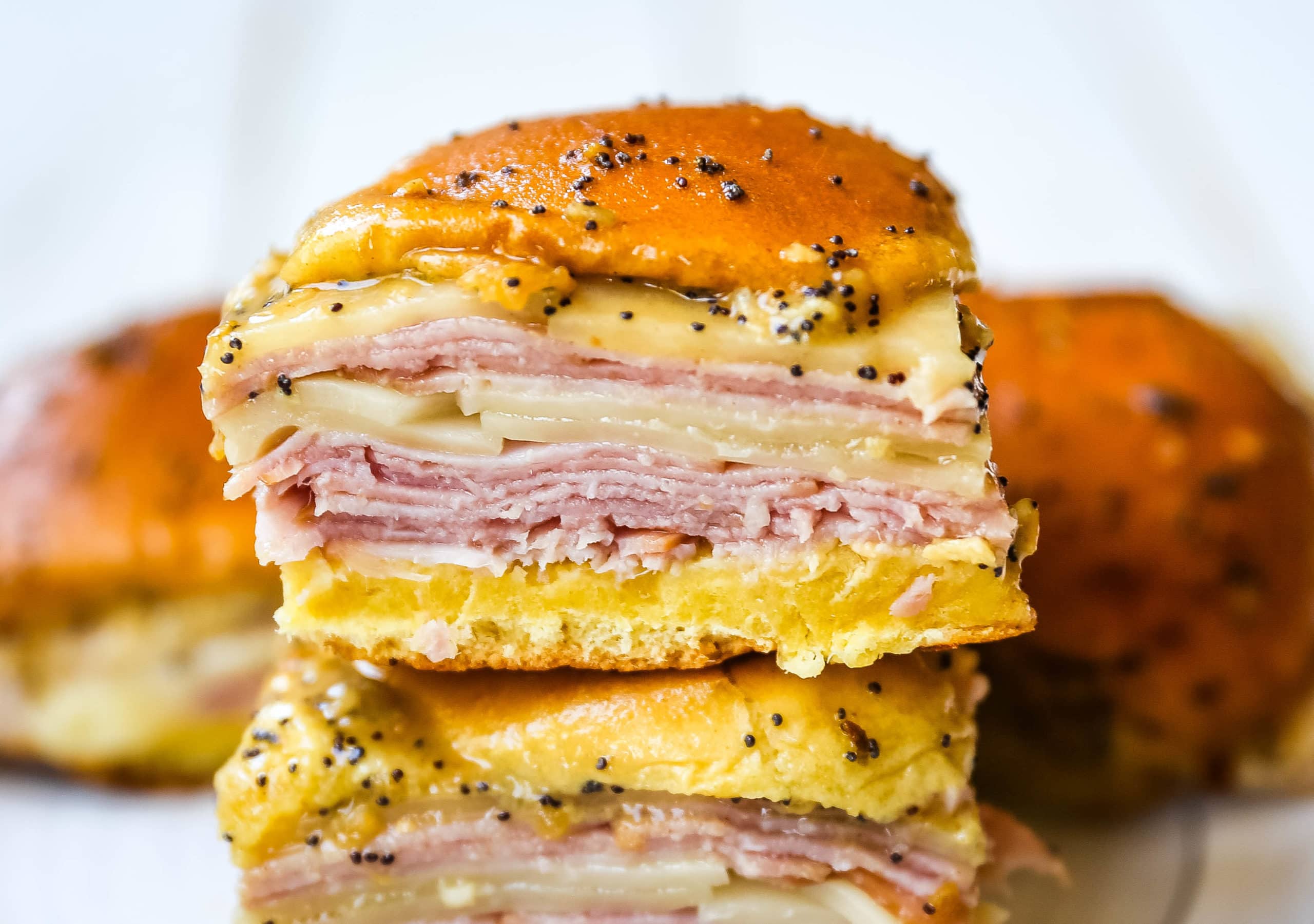 Ham and Cheese Sliders  These baked ham and cheese sliders and layered with ham, melted cheese, on a Hawaiian sweet roll, and basted with a flavorful, buttery sauce. www.modernhoney.com #sandwiches #sliders #hamandcheesesliders