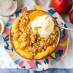 Peach Crisp. Fresh sweetened peaches with a brown sugar oat crumble topping with creamy vanilla ice cream. The perfect summer dessert! www.modernhoney.com #peach #peaches #peachcrisp #peachrecipes #peachdessert