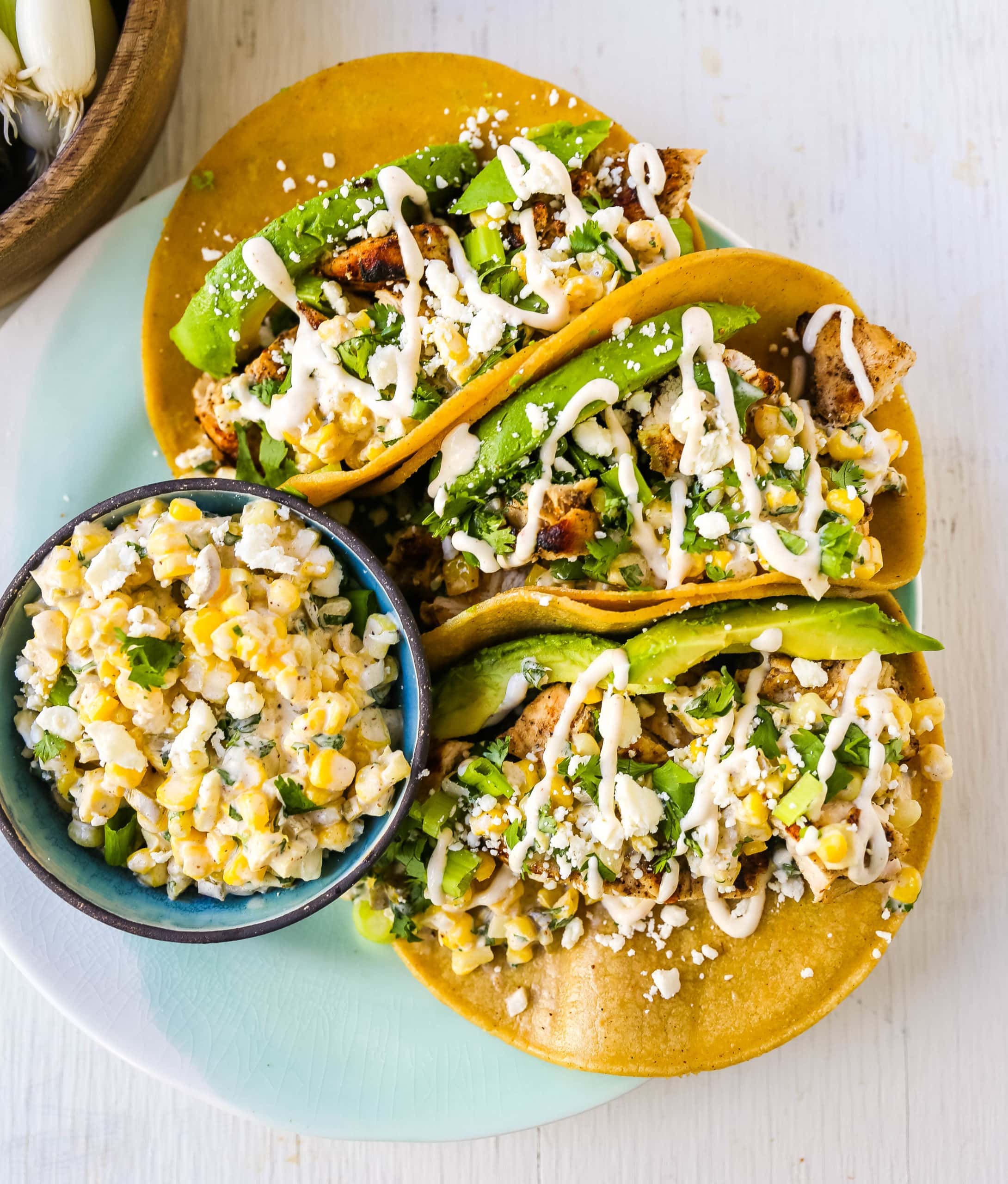 Mexican Street Corn Chicken Tacos Marinated grilled chicken with a homemade street corn salsa, fresh avocado, cotija cheese, and spiced Mexican crema. These tacos will become a family favorite in no time at all! www.modernhoney.com #taco #tacos #mexicanfood #chickentacos