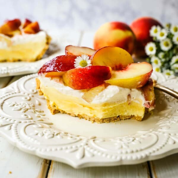 Peaches and Cream Pie. A quick and easy no-bake creamy peach pie with a buttery graham cracker crust, a sweet custard filling, fresh whipped cream, and sliced peaches.  www.modernhoney.com #pie #nobakedessert #nobakepie #peachdessert #peaches #peach