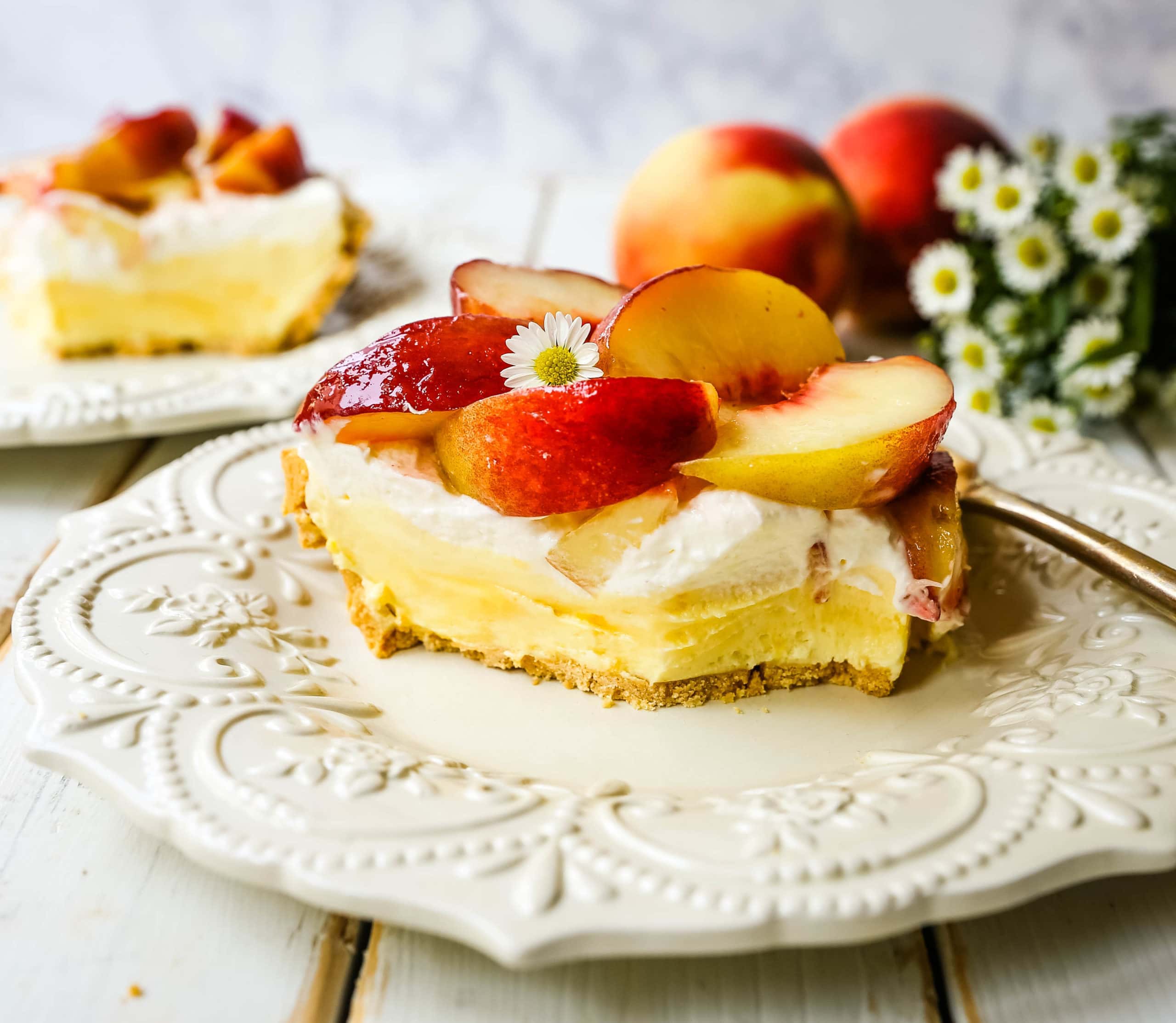 Peaches and Cream Pie. A quick and easy no-bake creamy peach pie with a buttery graham cracker crust, a sweet custard filling, fresh whipped cream, and sliced peaches.  www.modernhoney.com #pie #nobakedessert #nobakepie #peachdessert #peaches #peach 