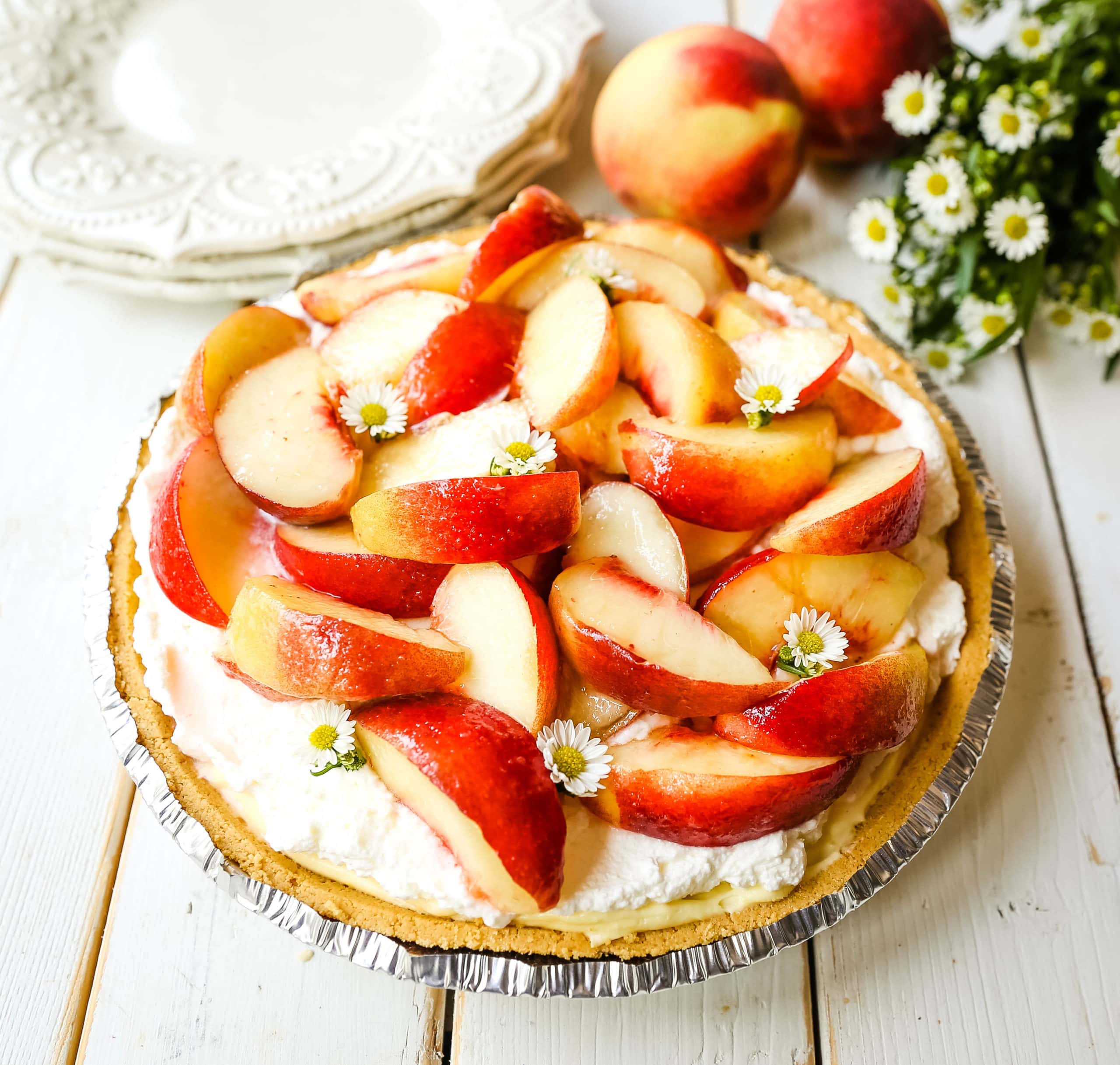 Peaches and Cream Pie. A quick and easy no-bake creamy peach pie with a buttery graham cracker crust, a sweet custard filling, fresh whipped cream, and sliced peaches.  www.modernhoney.com #pie #nobakedessert #nobakepie #peachdessert #peaches #peach