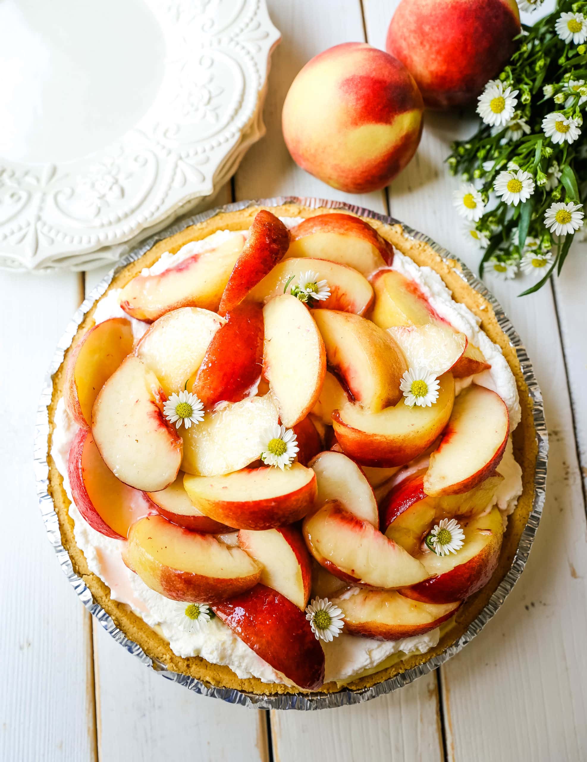 Peaches and Cream Pie. A quick and easy no-bake creamy peach pie with a buttery graham cracker crust, a sweet custard filling, fresh whipped cream, and sliced peaches.  www.modernhoney.com #pie #nobakedessert #nobakepie #peachdessert #peaches #peach