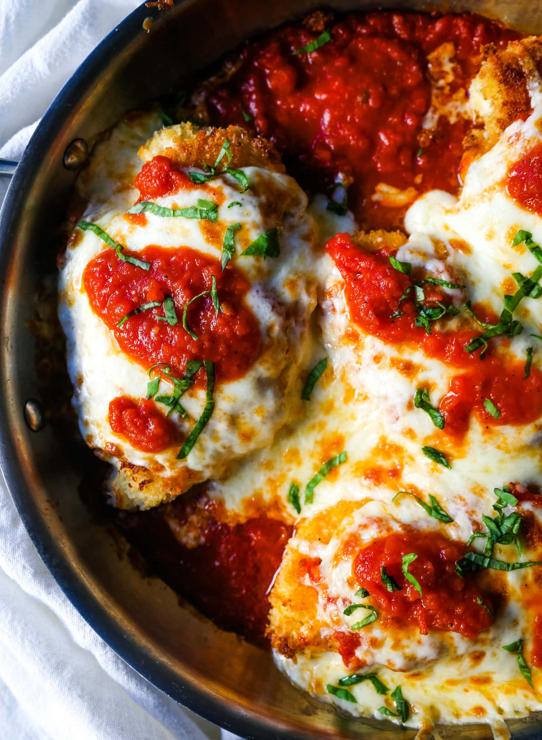 Chicken Parmesan. Panko-crusted chicken breast topped with homemade marinara sauce, melted whole milk mozzarella, and parmesan cheeses and baked until golden and bubbly. www.modernhoney.com #chicken #chickenparmesan #italian