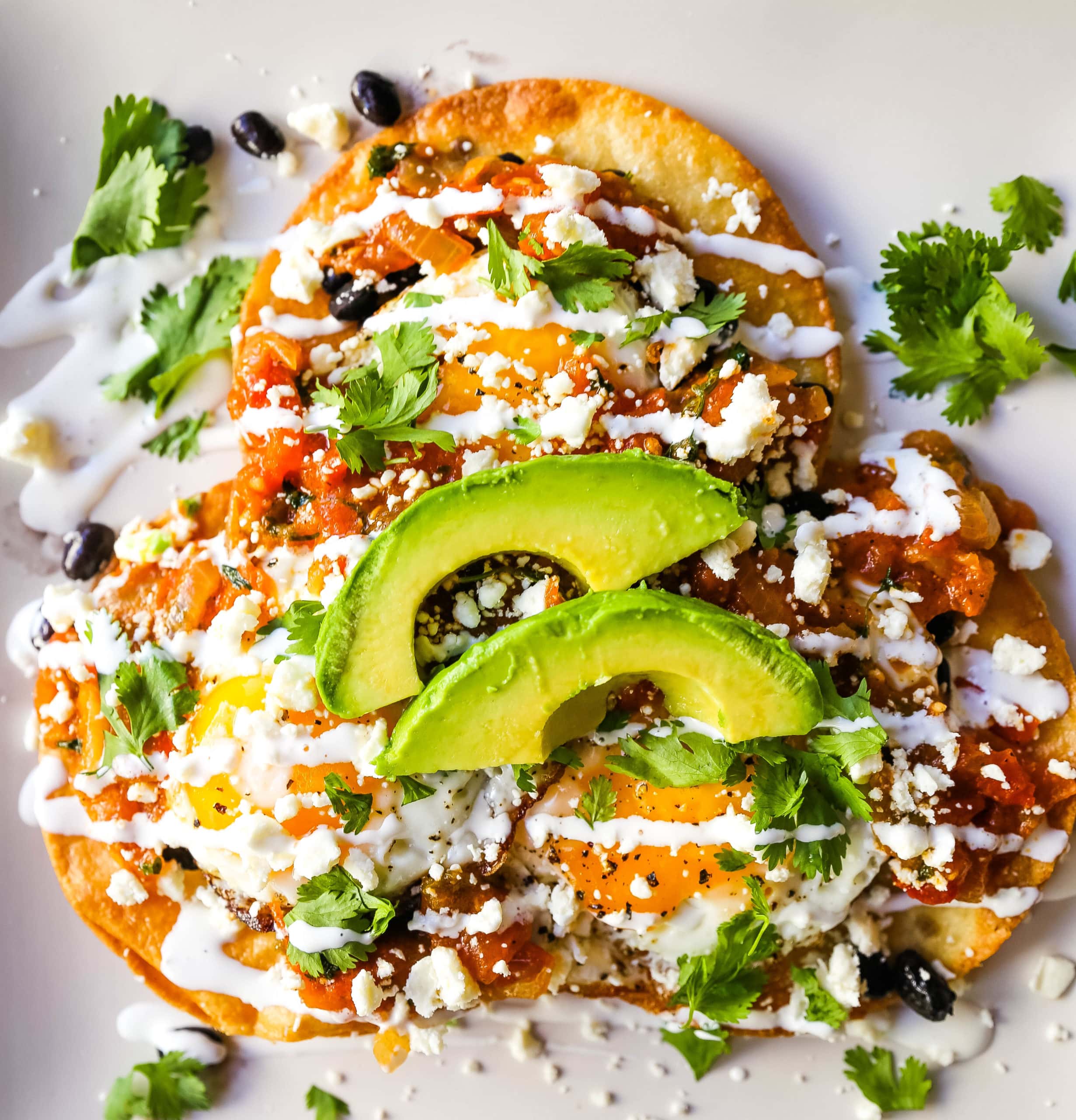 Huevos Rancheros. A traditional Mexican breakfast dish made with fried corn tortillas, fried egg, ranchera salsa, beans, avocado, cheese, and salsa.  #huevosrancheros #mexican #mexicanfood #breakfast