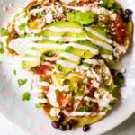 Huevos Rancheros. A traditional Mexican breakfast dish made with fried corn tortillas, fried egg, ranchera salsa, beans, avocado, cheese, and salsa. #huevosrancheros #mexican #mexicanfood #breakfast