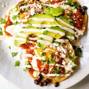 Huevos Rancheros. A traditional Mexican breakfast dish made with fried corn tortillas, fried egg, ranchera salsa, beans, avocado, cheese, and salsa.  #huevosrancheros #mexican #mexicanfood #breakfast