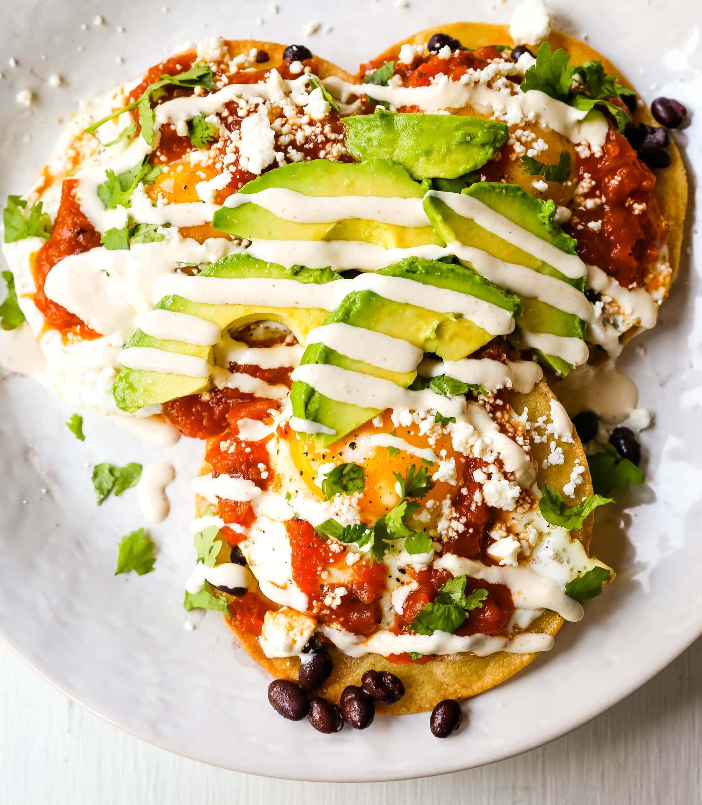 Huevos Rancheros. A traditional Mexican breakfast dish made with fried corn tortillas, fried egg, ranchera salsa, beans, avocado, cheese, and salsa.  #huevosrancheros #mexican #mexicanfood #breakfast