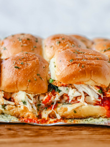 Baked Chicken Parm Sliders Chicken topped with a fresh marinara sauce topped with fresh mozzarella cheese and baked on Hawaiian sweet rolls and slathered with garlic butter. www.modernhoney.com #italian