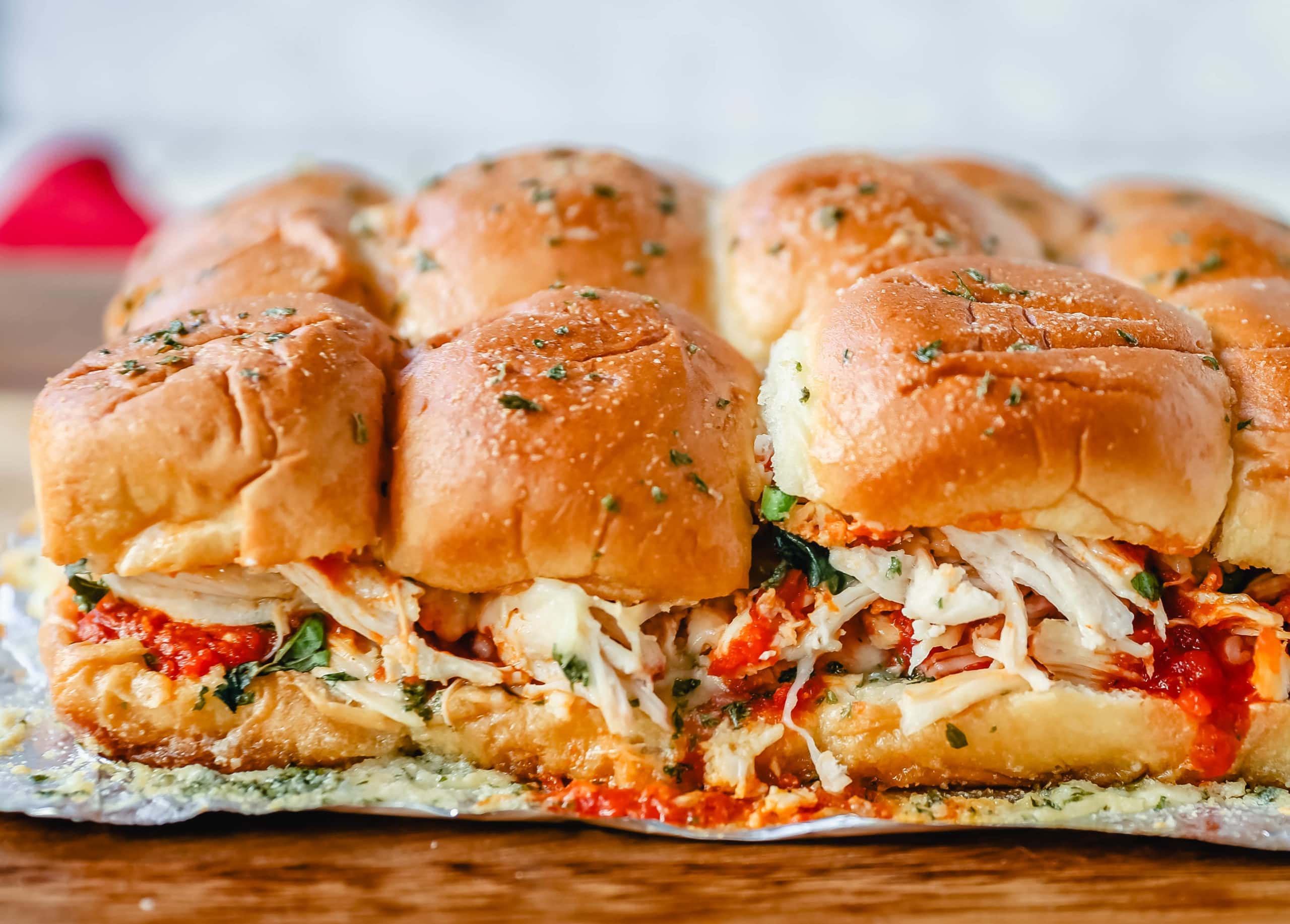 Baked Chicken Parm Sliders Chicken topped with a fresh marinara sauce topped with fresh mozzarella cheese and baked on Hawaiian sweet rolls and slathered with garlic butter. www.modernhoney.com #italian