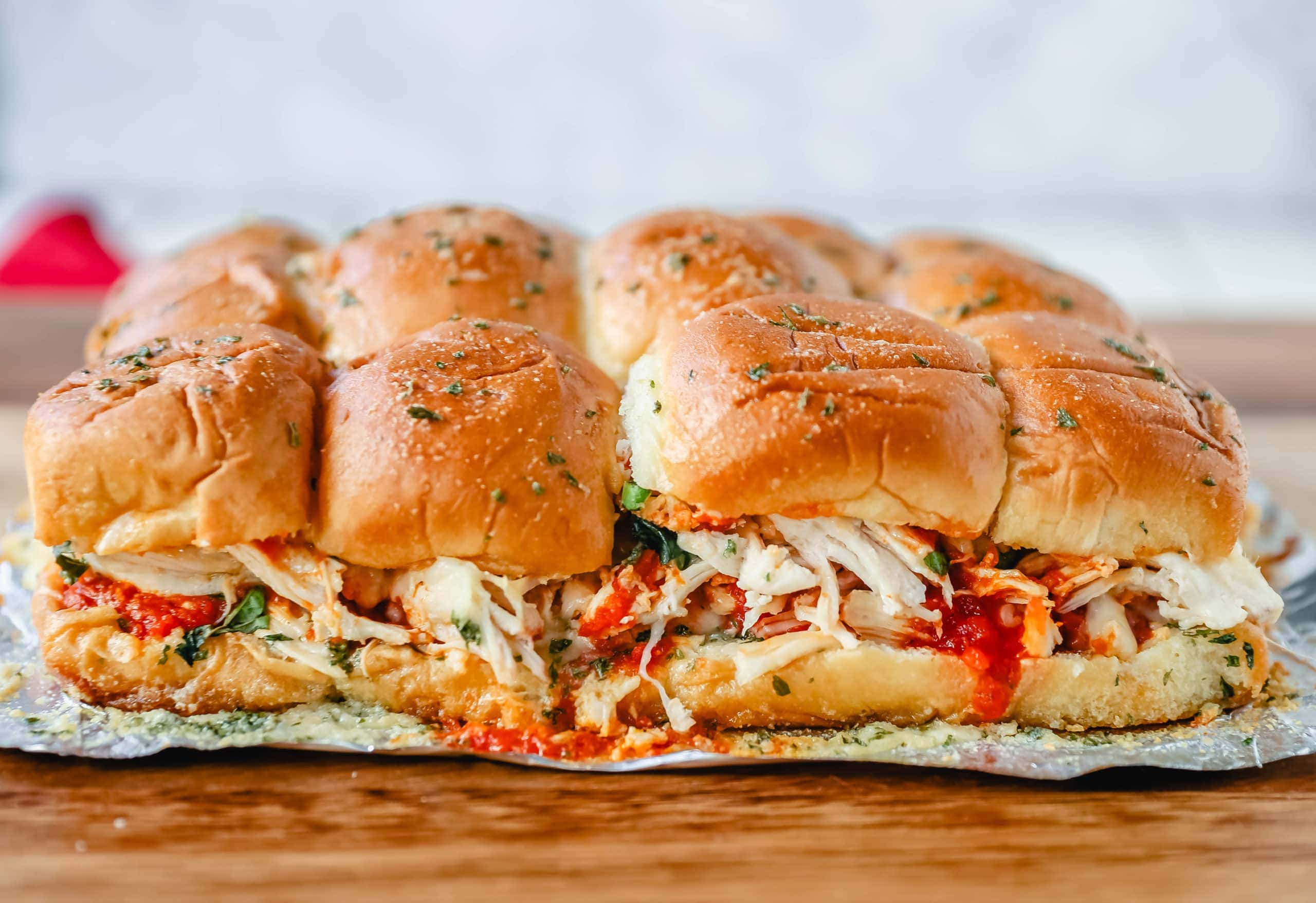 Baked Chicken Parm Sliders Chicken topped with a fresh marinara sauce topped with fresh mozzarella cheese and baked on Hawaiian sweet rolls and slathered with garlic butter. www.modernhoney.com #italian