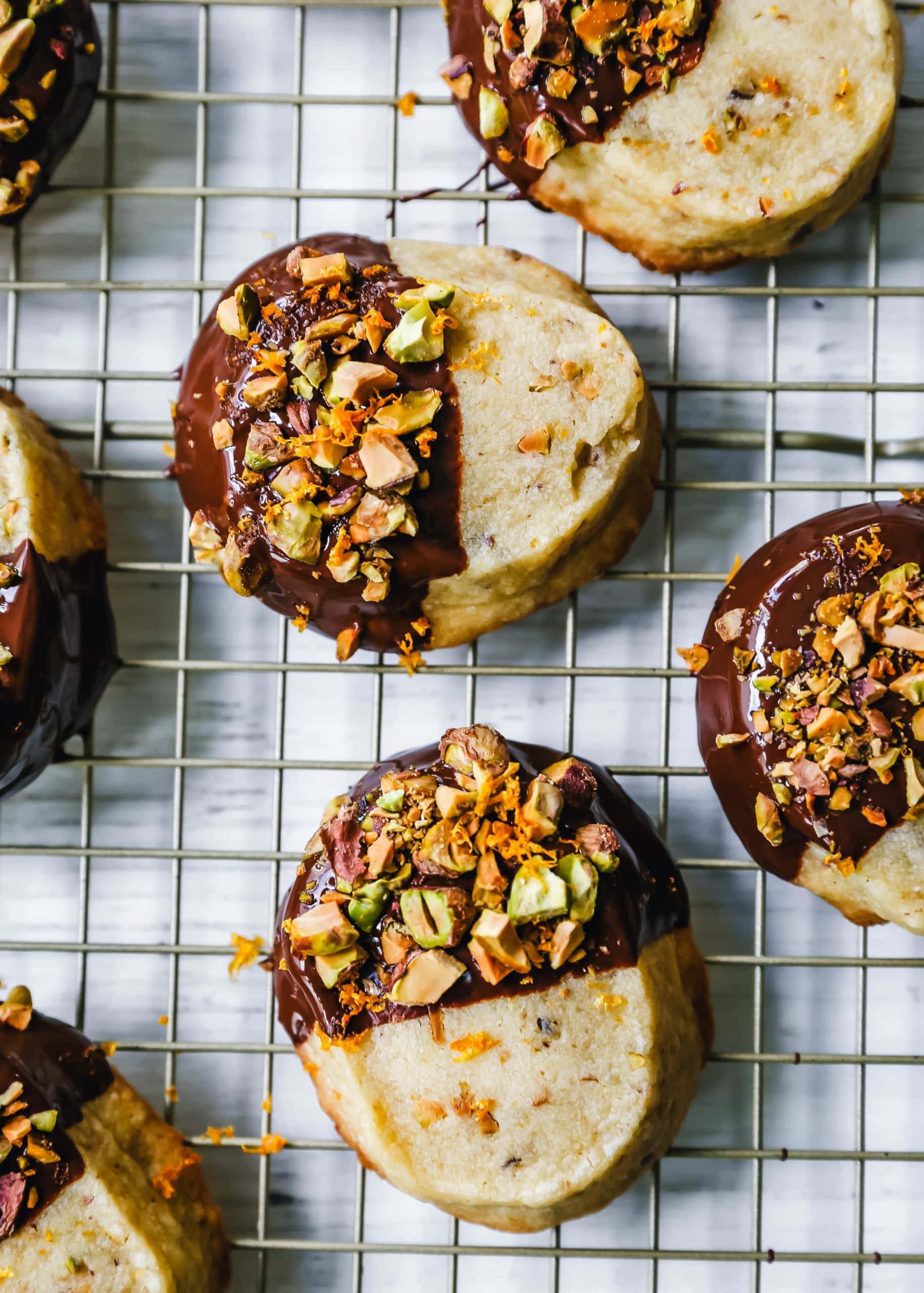 Chocolate-Dipped Pistachio Shortbread Cookies Rich, buttery shortbread butter cookies with crunchy pistachios and dipped in melted chocolate and sprinkled with fresh orange zest and chopped pistachios. A beautiful and festive Christmas cookie! www.modernhoney.com #shortbread #shortbreadcookie #christmascookie #christmascookies