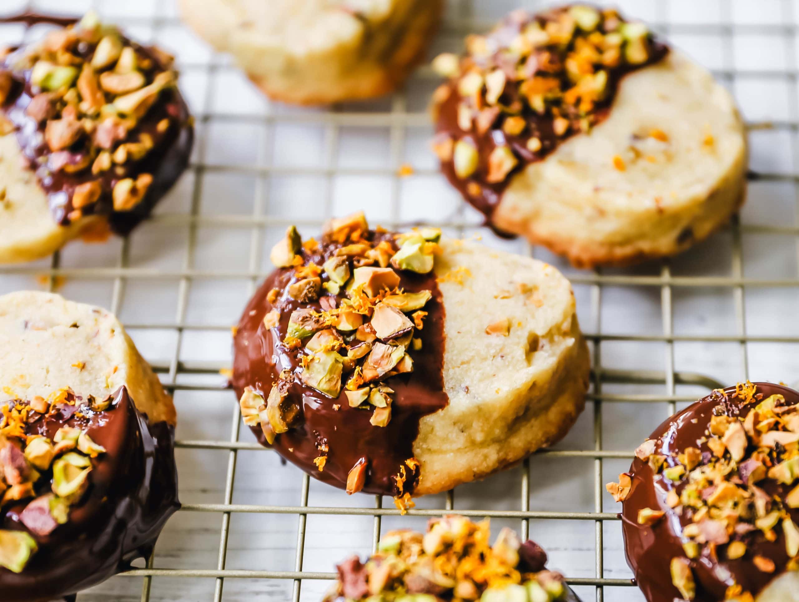 Chocolate-Dipped Pistachio Shortbread Cookies Rich, buttery shortbread butter cookies with crunchy pistachios and dipped in melted chocolate and sprinkled with fresh orange zest and chopped pistachios. A beautiful and festive Christmas cookie! www.modernhoney.com #shortbread #shortbreadcookie #christmascookie #christmascookies