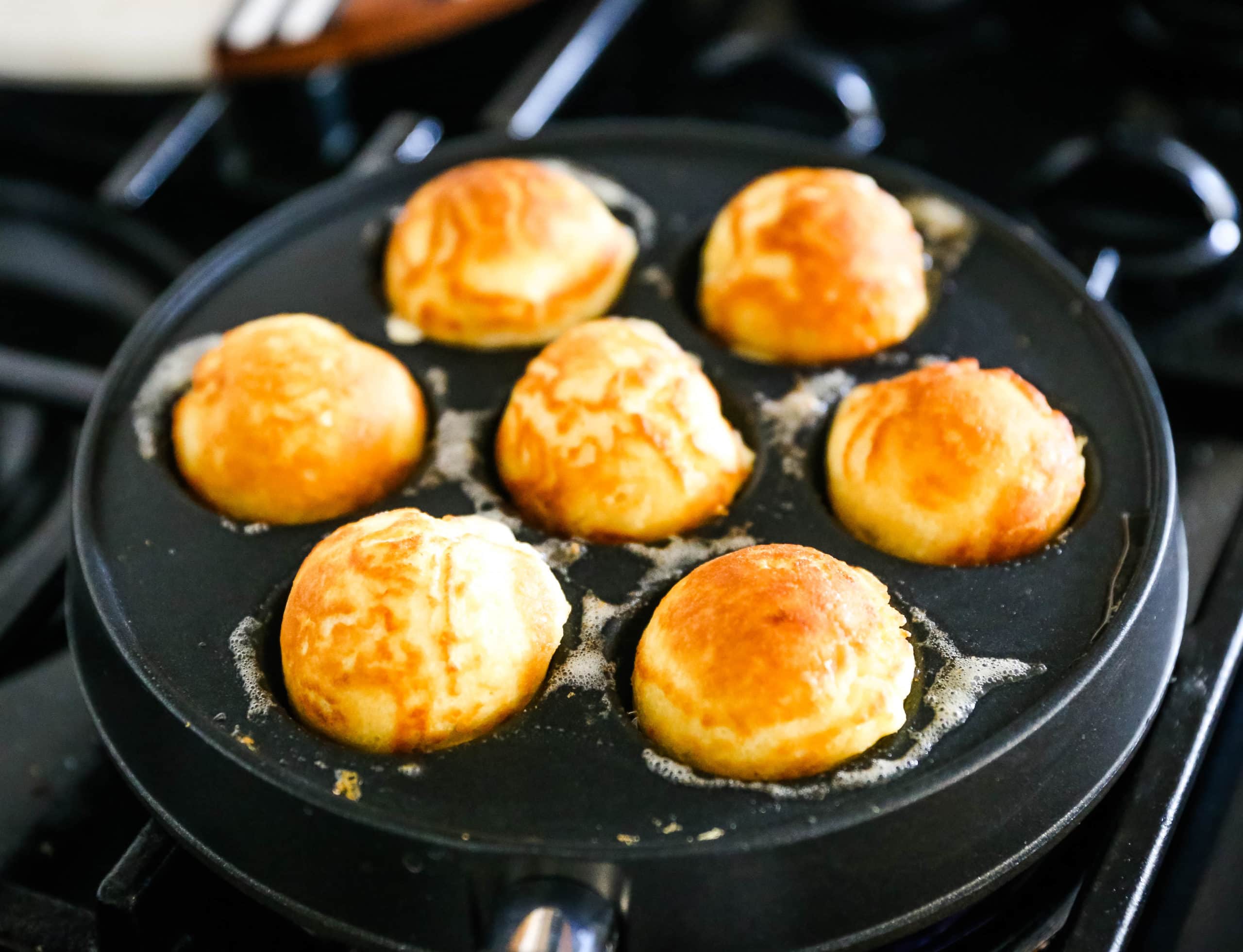 Aebleskiver Danish Pancakes a traditional Danish breakfast or dessert popular in Denmark is a circle pancake cooked in an aebleskiver pan and served with jam, powdered sugar, syrup, and fruit.  www.modernhoney.com #aebleskivers #danishpancakes #pancakes