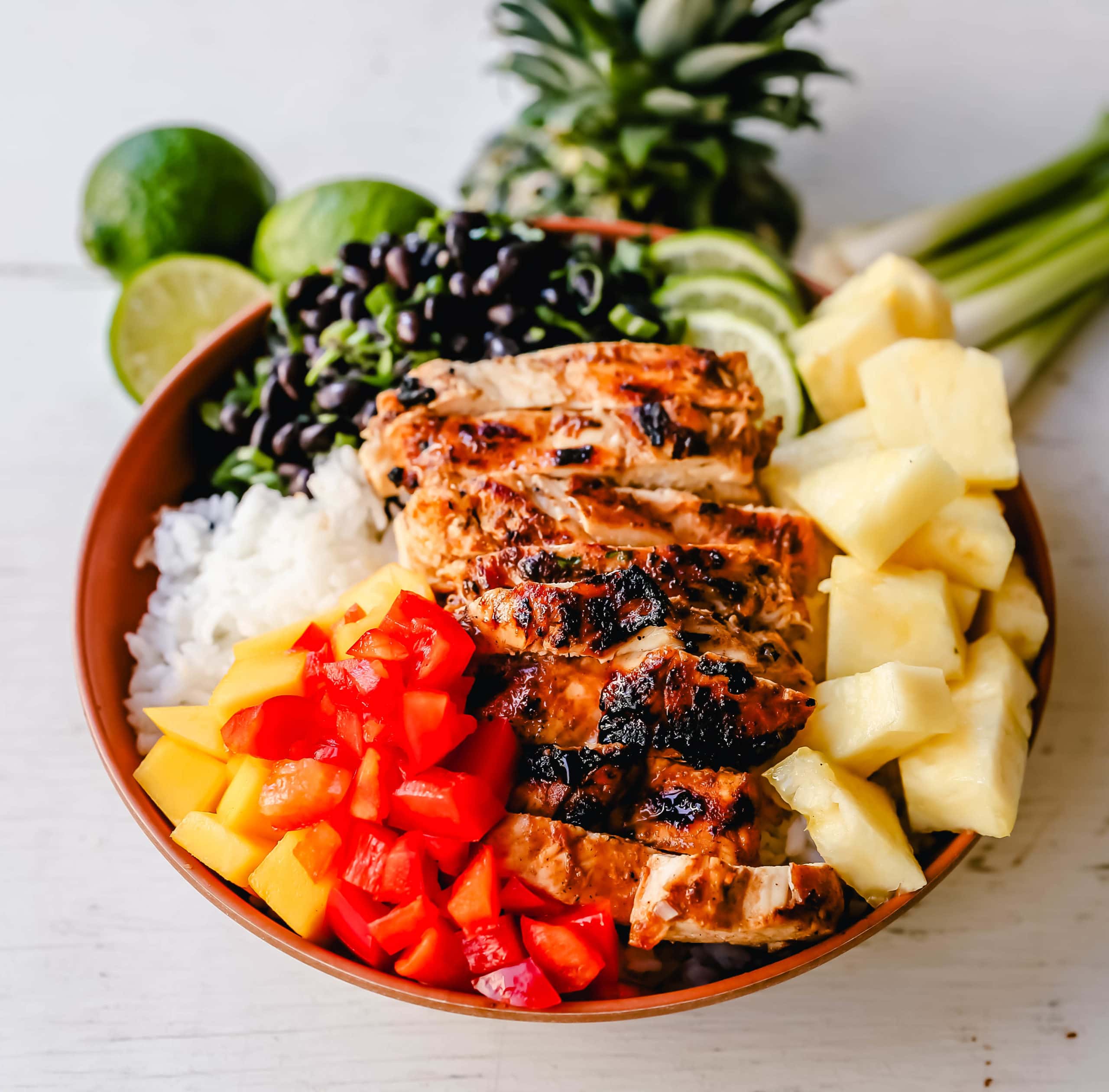 Jerk Chicken Bowl Jamaican spiced grilled Jerk Chicken with rice, black beans, cilantro, fresh pineapple and mango, and red peppers. www.modernhoney.com #jerkchicken #chicken #chickenbowl