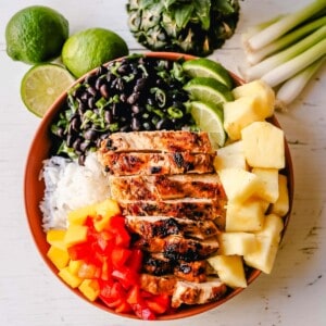 Jerk Chicken Bowl Jamaican spiced grilled Jerk Chicken with rice, black beans, cilantro, fresh pineapple and mango, and red peppers. www.modernhoney.com #jerkchicken #chicken #chickenbowl