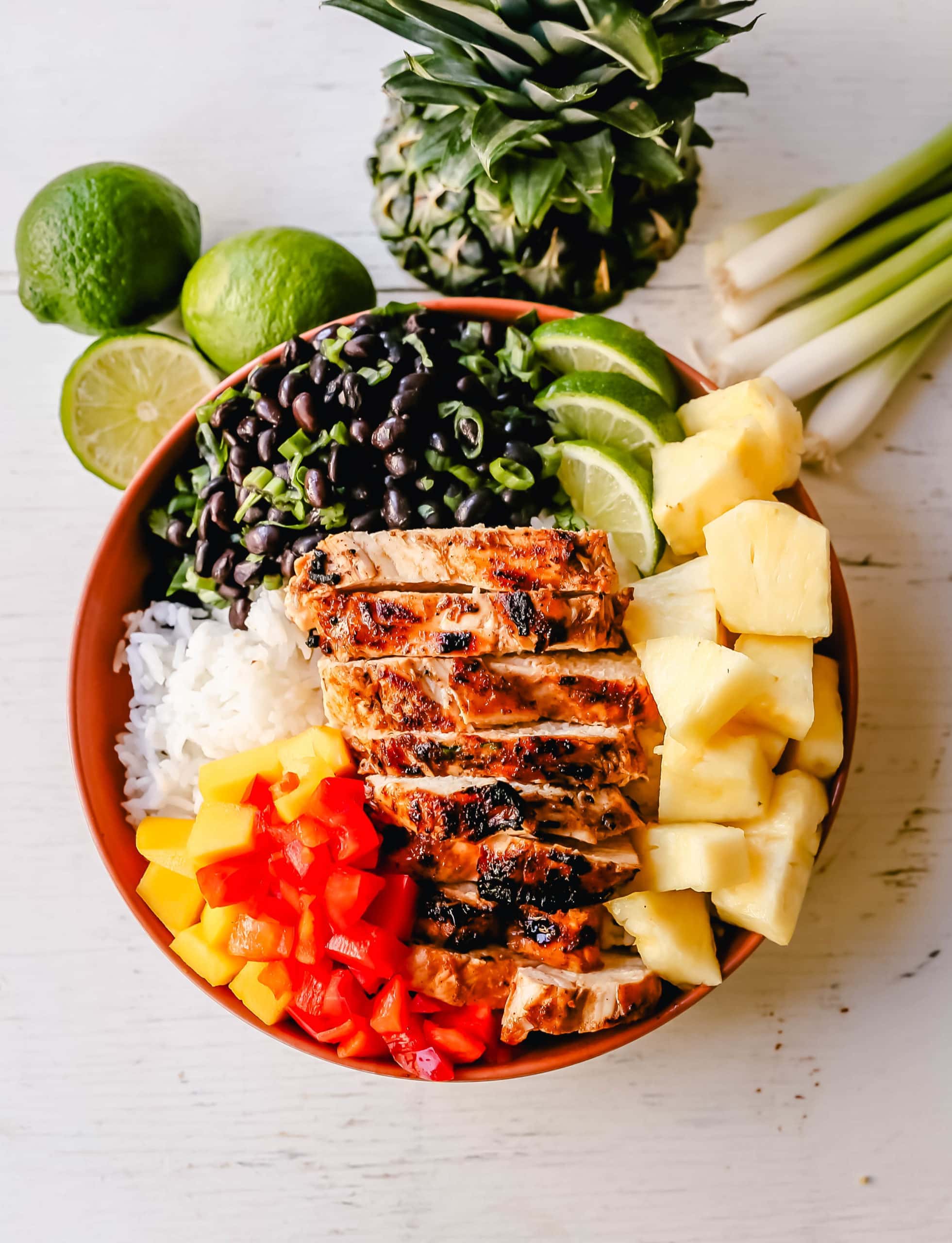 Jerk Chicken Bowl Jamaican spiced grilled Jerk Chicken with rice, black beans, cilantro, fresh pineapple and mango, and red peppers. www.modernhoney.com #jerkchicken #chicken #chickenbowl