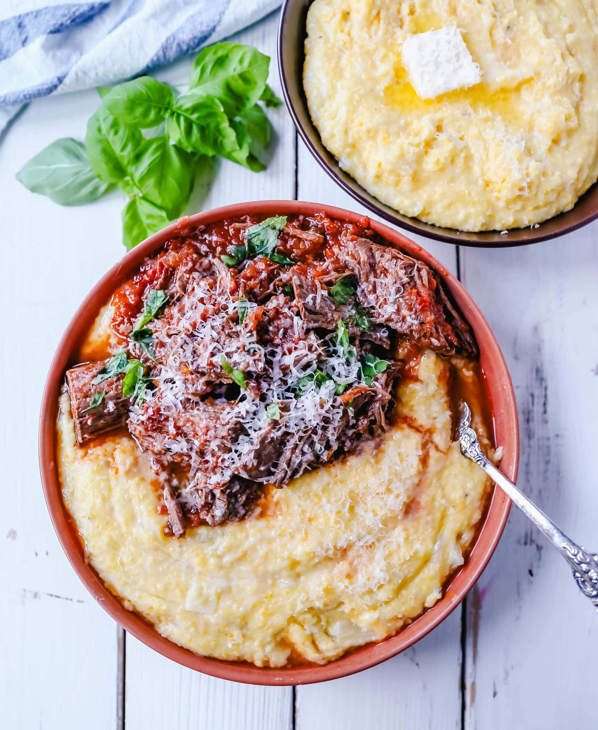 Italian Braised Beef Ragu with Parmesan Polenta Slow-cooked braised beef in a hearty homemade Italian tomato garlic sauce on top of creamy parmesan polenta. A true comfort food! www.modernhoney.com #ragu #italian #italianfood #polenta #beef #slowcooker