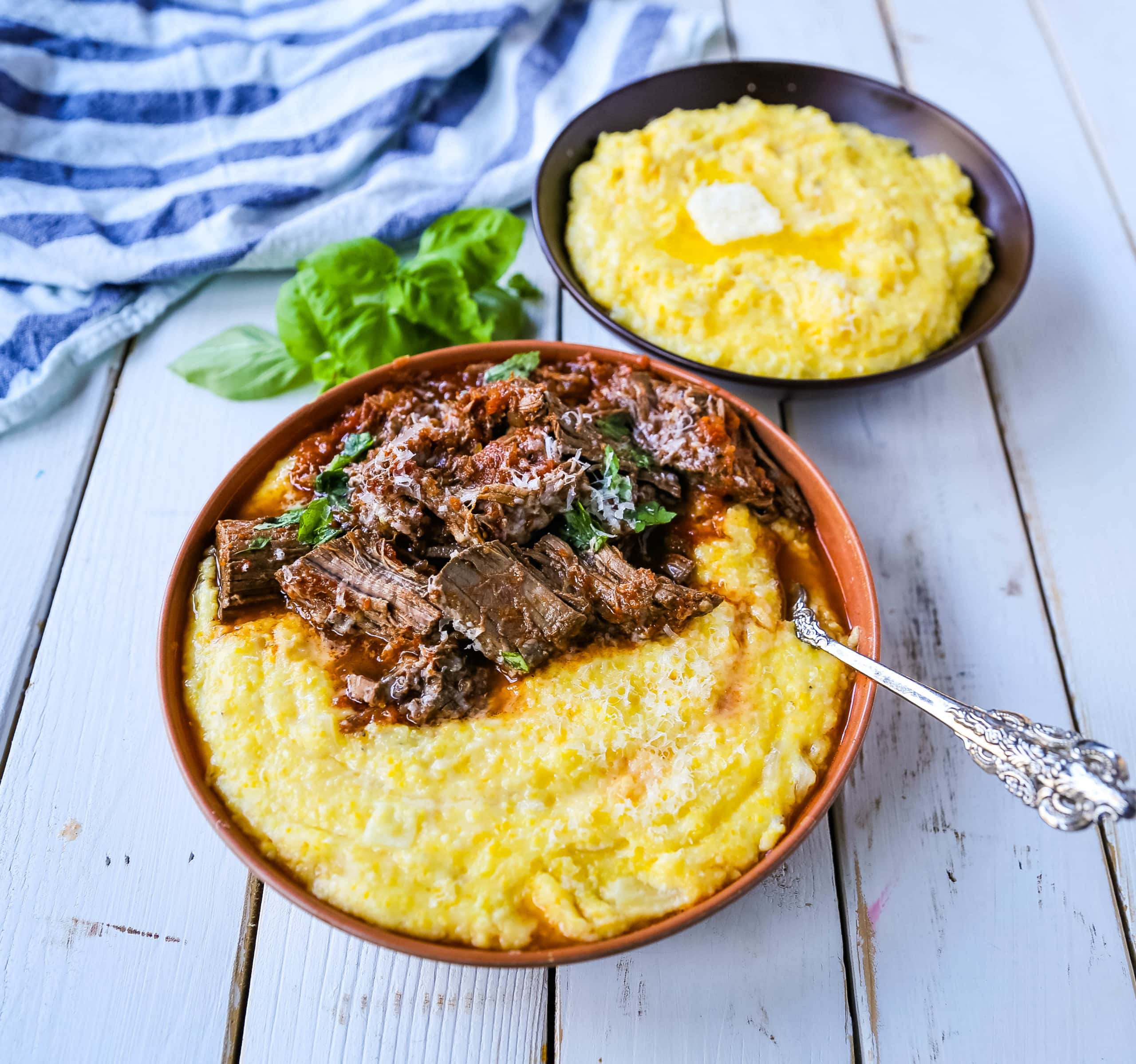 Italian Braised Beef Ragu with Parmesan Polenta Slow-cooked braised beef in a hearty homemade Italian tomato garlic sauce on top of creamy parmesan polenta. A true comfort food! www.modernhoney.com #ragu #italian #italianfood #polenta #beef #slowcooker