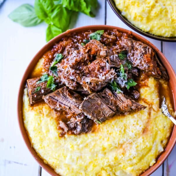 Italian Braised Beef Ragu with Parmesan Polenta Slow-cooked braised beef in a hearty homemade Italian tomato garlic sauce on top of creamy parmesan polenta. A true comfort food! www.modernhoney.com #ragu #italian #italianfood #polenta #beef #slowcooker