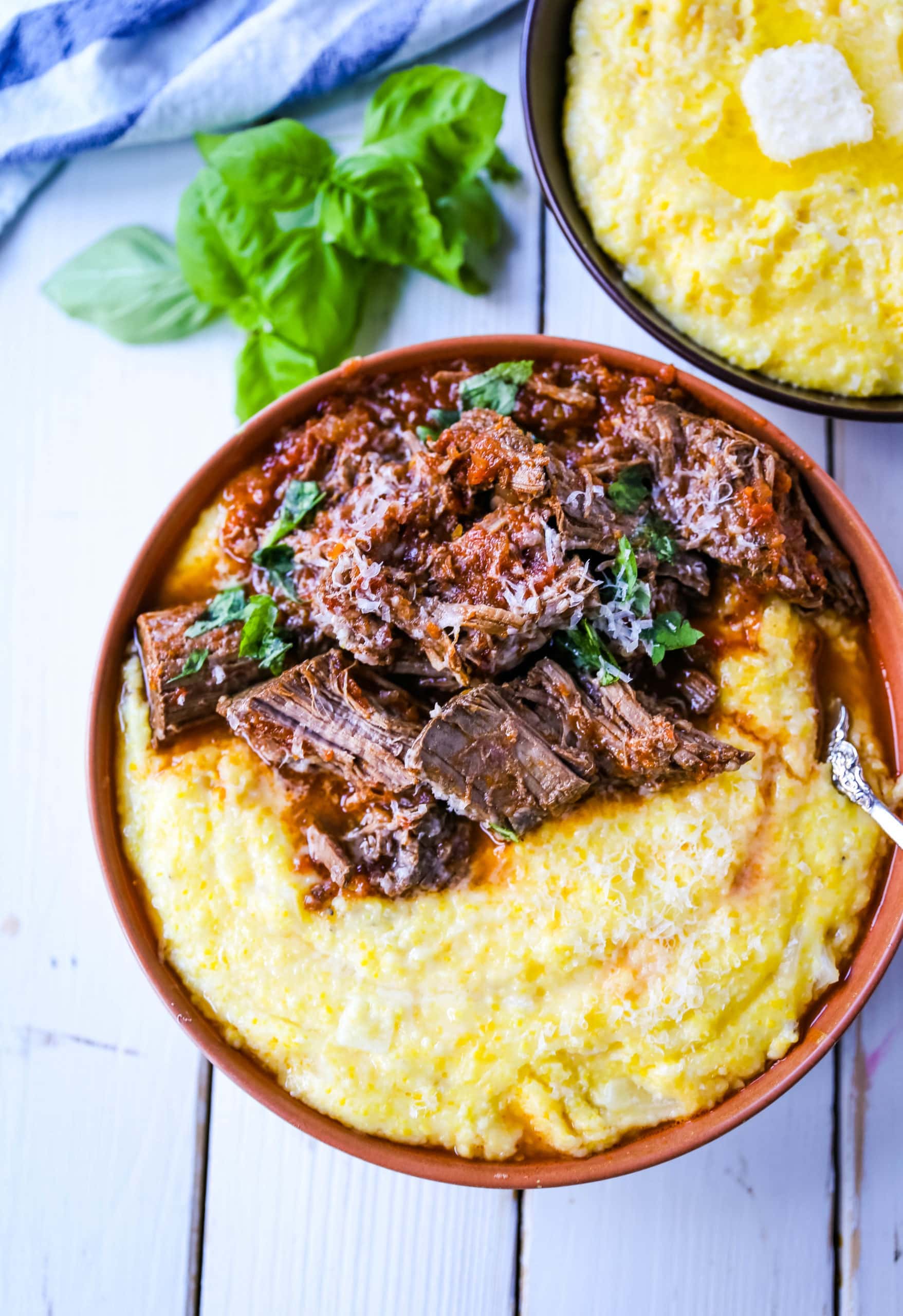 Italian Braised Beef Ragu with Parmesan Polenta Slow-cooked braised beef in a hearty homemade Italian tomato garlic sauce on top of creamy parmesan polenta. A true comfort food! www.modernhoney.com #ragu #italian #italianfood #polenta #beef #slowcooker