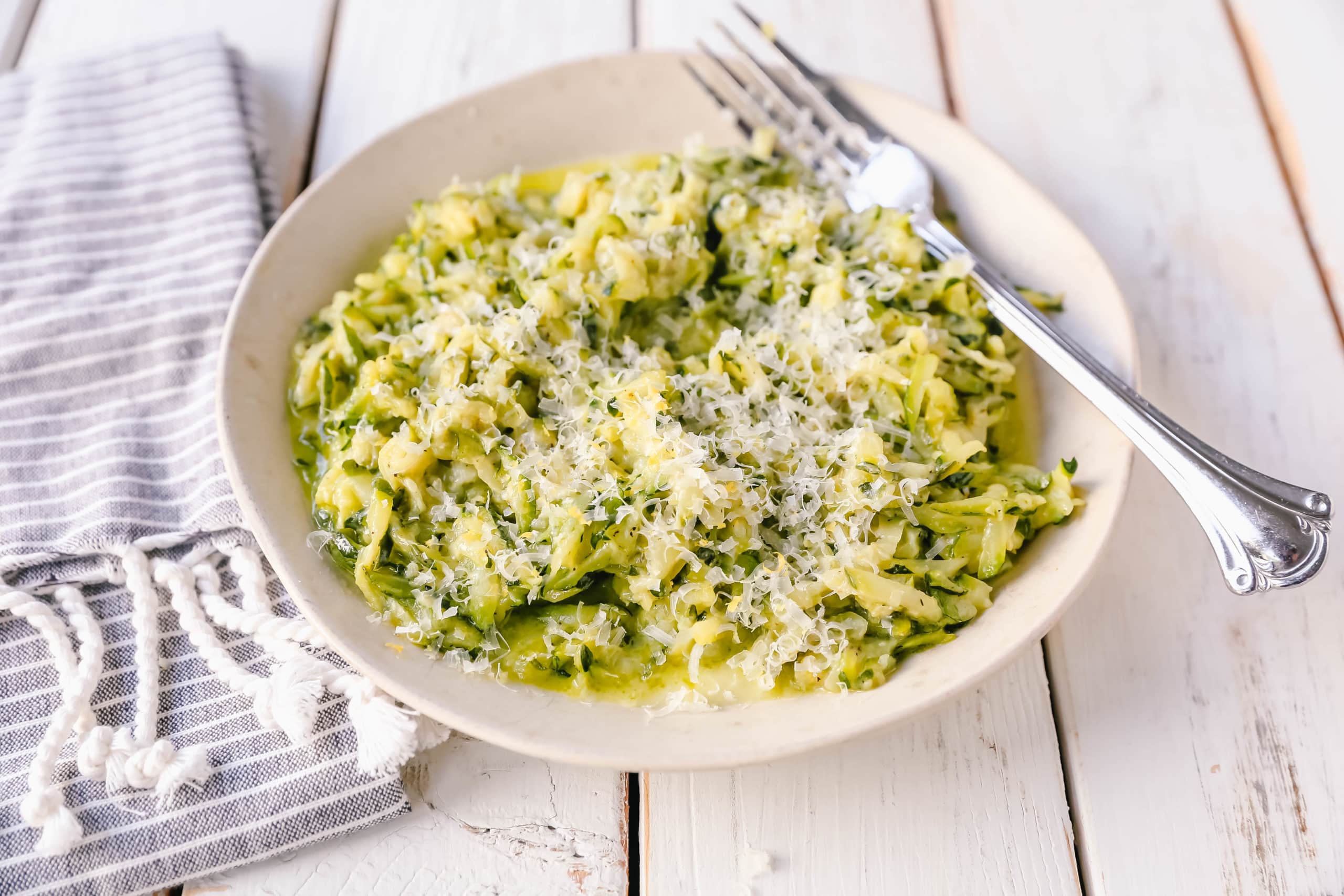Shredded Sautéed Zucchini with Parmesan. Simple shredded fresh zucchini sauteed until tender and topped with salt, pepper, garlic, and parmesan cheese. This zucchini recipe pairs so well with beef and chicken. #zucchini #sidedish #vegetables