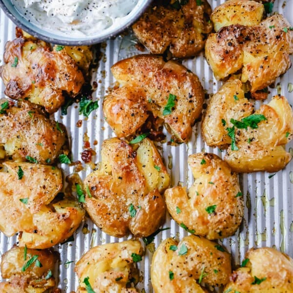 Crispy Smashed Potatoes. Crispy smashed potatoes with creamy, fluffy centers and crispy outsides. Petite potatoes topped with olive oil, salted butter, salt, and pepper and baked until crispy and topped with a garlic cheddar sour cream dip. The best smashed potatoes recipe!