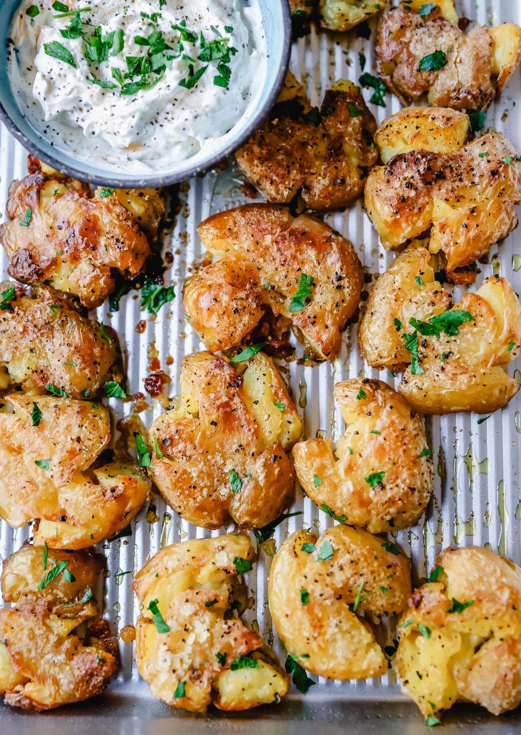 Crispy Smashed Potatoes. Crispy smashed potatoes with creamy, fluffy centers and crispy outsides. Petite potatoes topped with olive oil, salted butter, salt, and pepper and baked until crispy and topped with a garlic cheddar sour cream dip. The best smashed potatoes recipe! 