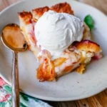 Texas Style Peach Cobbler. Fresh peaches sweetened with sugar and topped with a creamy buttery cake-like topping. A Texas favorite dessert!  #peaches #peachdessert #peachcobbler