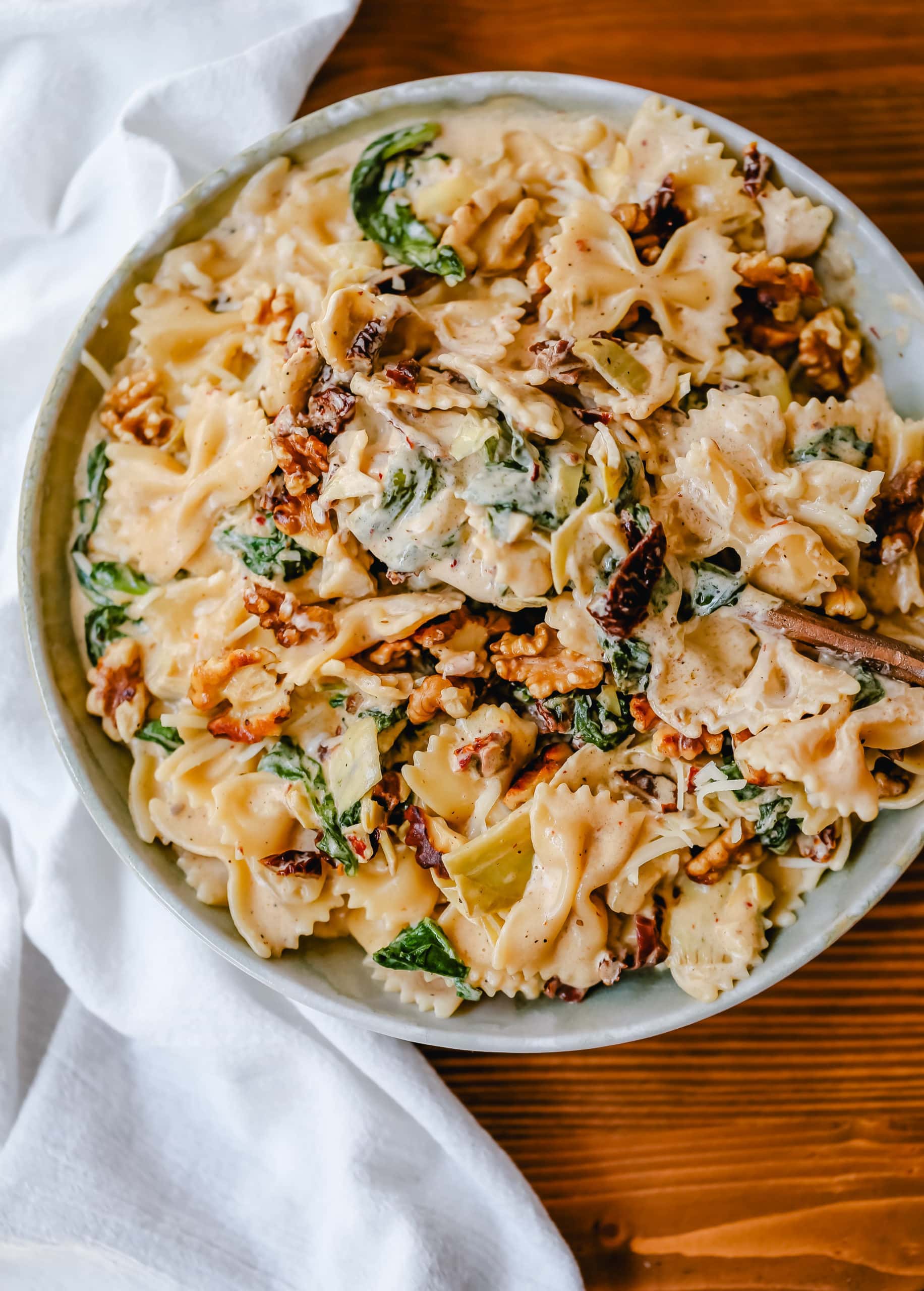 Creamy Bowtie Pasta with Sundried Tomatoes Bowtie Pasta tossed with a garlic sundried tomato cream sauce with artichoke hearts and parmesan cheese and crunchy toasted walnuts. A quick 20-minute weeknight meal. #pasta #dinner