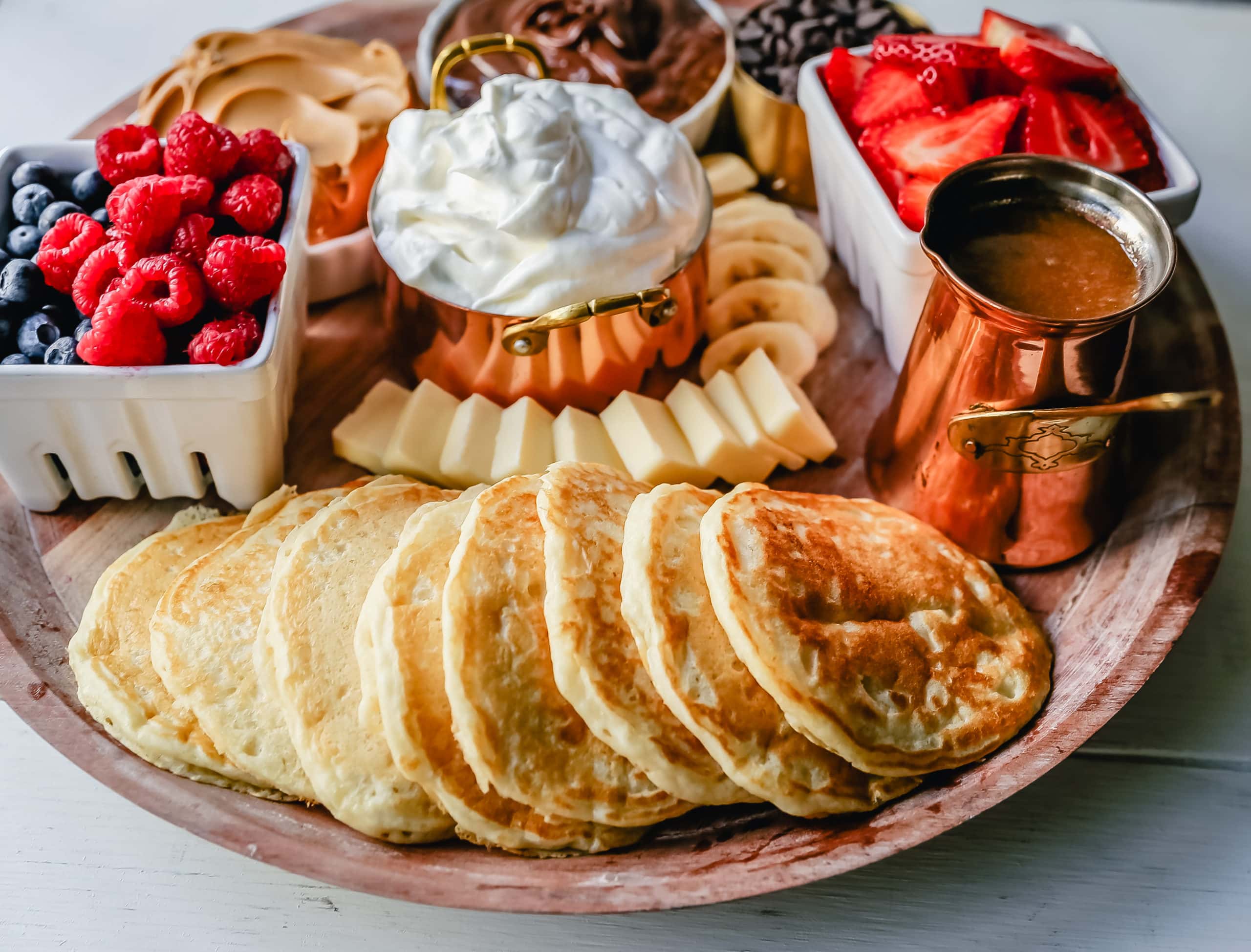 Breakfast Pancake Board. The perfect breakfast for entertaining! Homemade buttermilk pancakes topped with all of your favorite toppings -- fresh berries, whipped cream, homemade syrup, Nutella, chocolate chips, peanut butter, and more. 