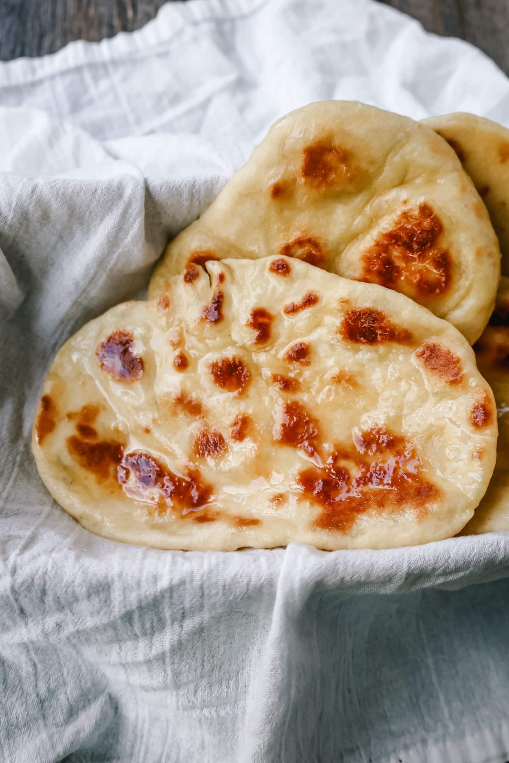 Light, fluffy, buttery homemade naan bread that's even better than what you find in restaurants. This is the best naan bread recipe, made easy on the stovetop.