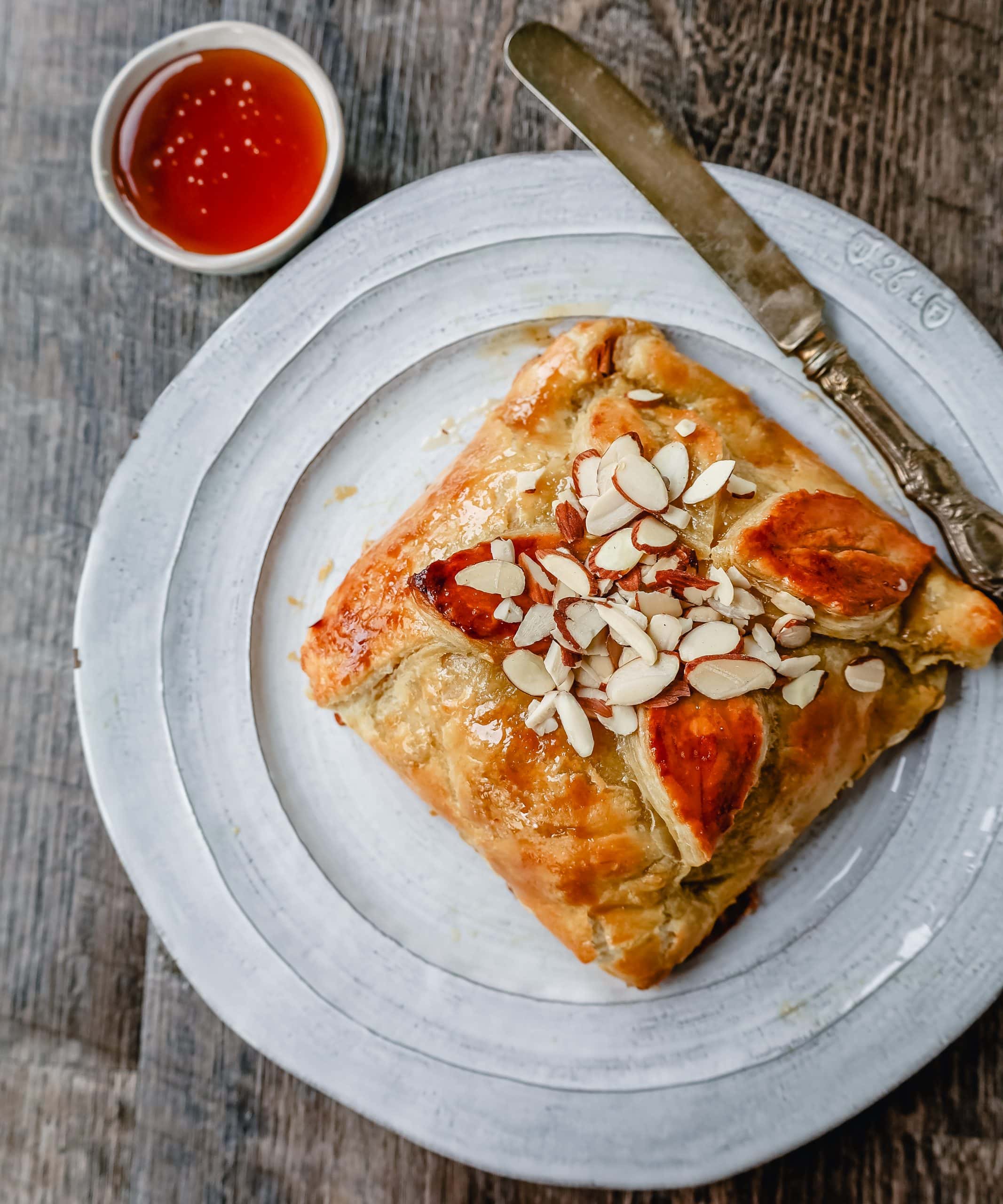 Honey Almond Puff Pastry Wrapped Brie Brie cheese wrapped in buttery puff pastry with local honey and sliced almonds. This is a sweet and salty festive party appetizer.