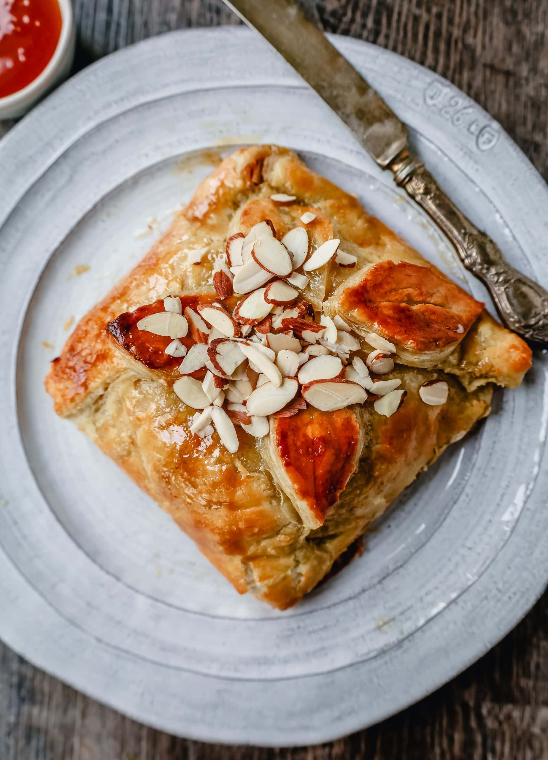 Honey Almond Puff Pastry Wrapped Brie Brie cheese wrapped in buttery puff pastry with local honey and sliced almonds. This is a sweet and salty festive party appetizer.